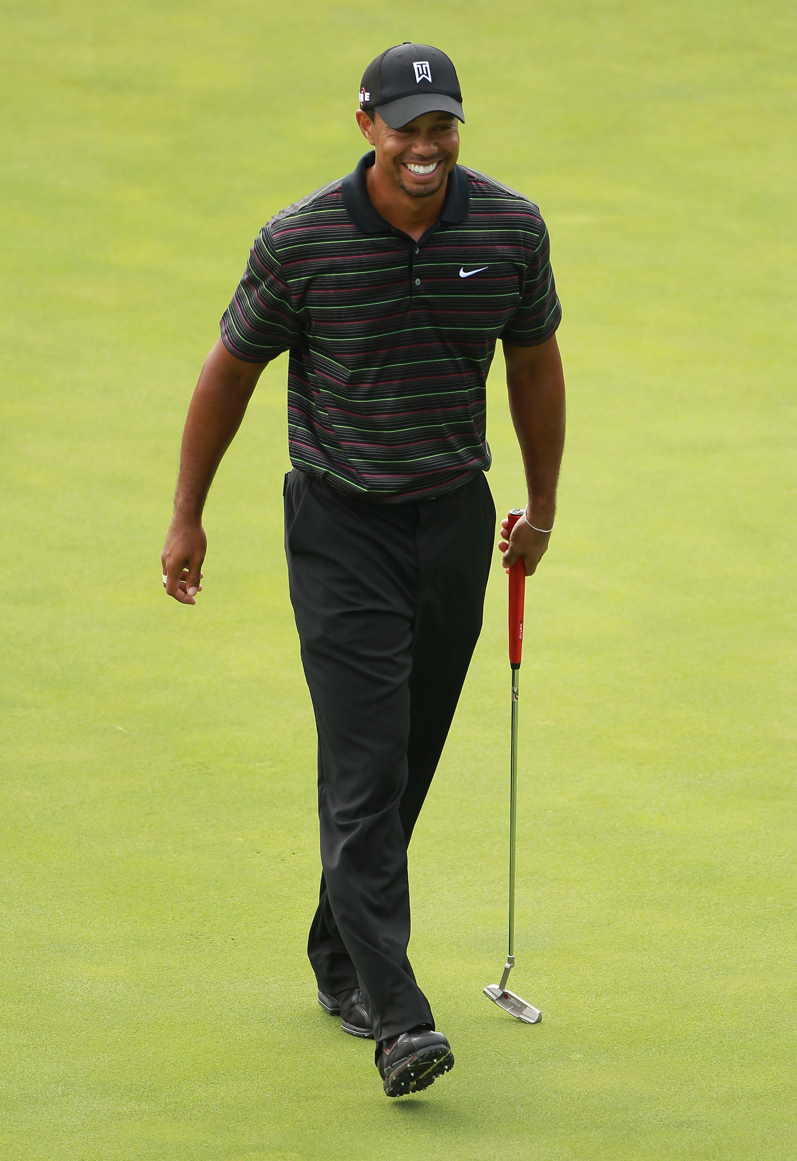 KOHLER, WI - AUGUST 09:  Tiger Woods smiles during a practice round prior to the start of the 92nd PGA Championship on the Straits Course at Whistling Straits on August 9, 2010 in Kohler, Wisconsin.  (Photo by Andrew Redington/Getty Images)
