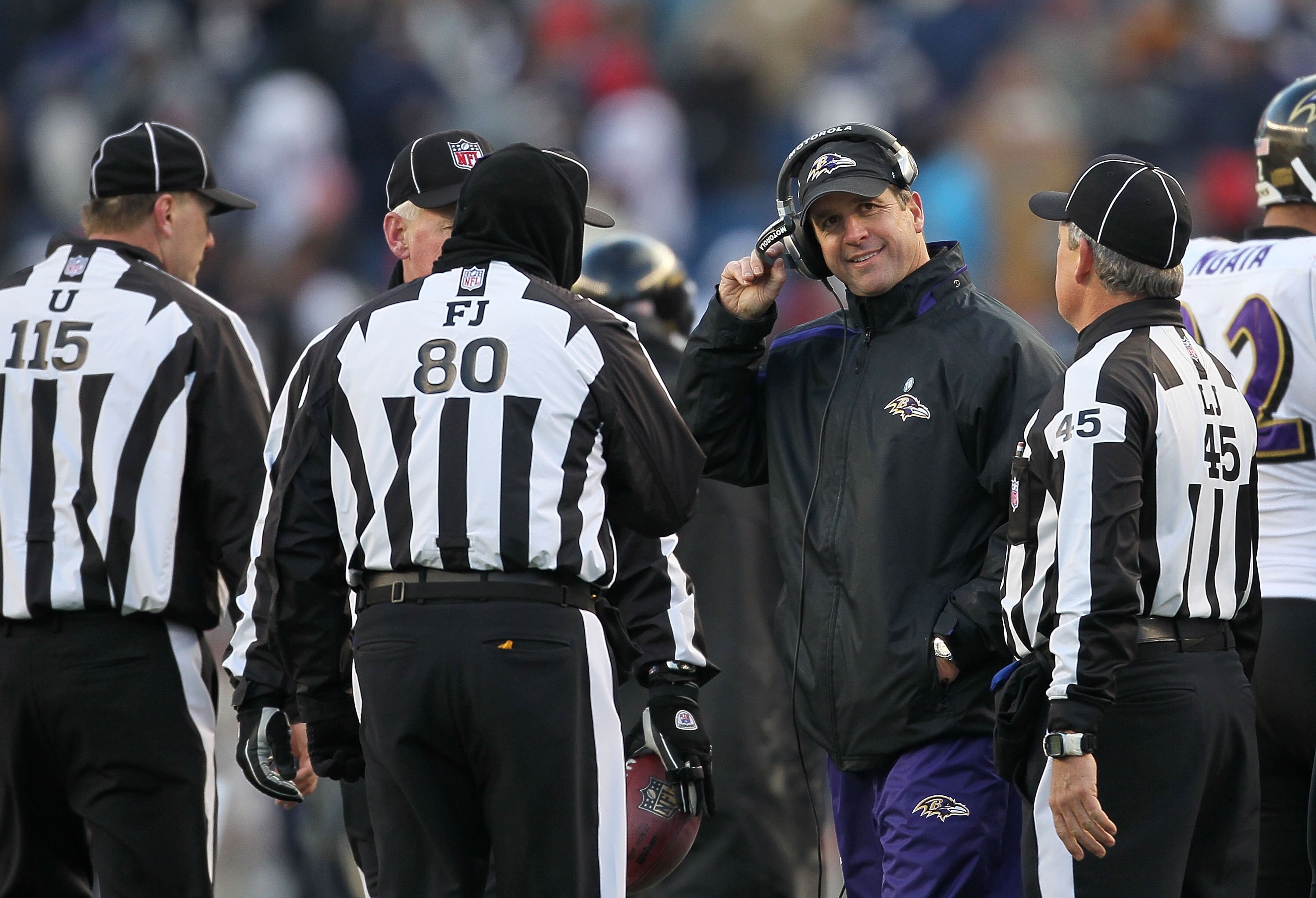FOXBORO, MA - JANUARY 10:  Head coach John Harbaugh of the Baltimore Ravens talks with a group of referee and officials against the New England Patriots during the 2010 AFC wild-card playoff game at Gillette Stadium on January 10, 2010 in Foxboro, Massach
