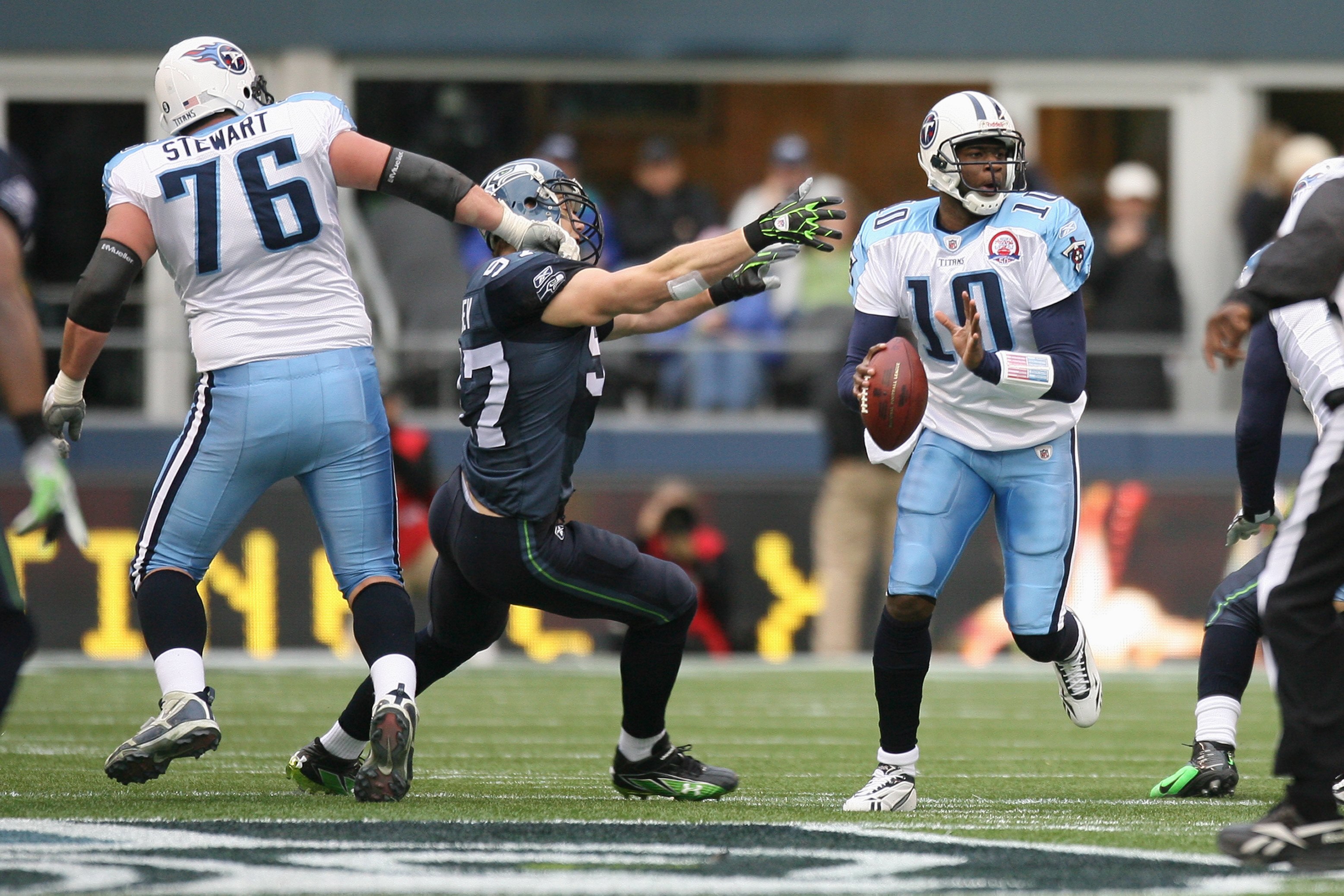 SEATTLE - JANUARY 03:  Vince Young #10 of the Tennessee Titans looks for a receiver while being pressured by Patrick Kerney #97 of the Seattle Seahawks as David Stewart #76 blocks on January 3, 2010 at Qwest Field in Seattle, Washington. (Photo by Otto Gr