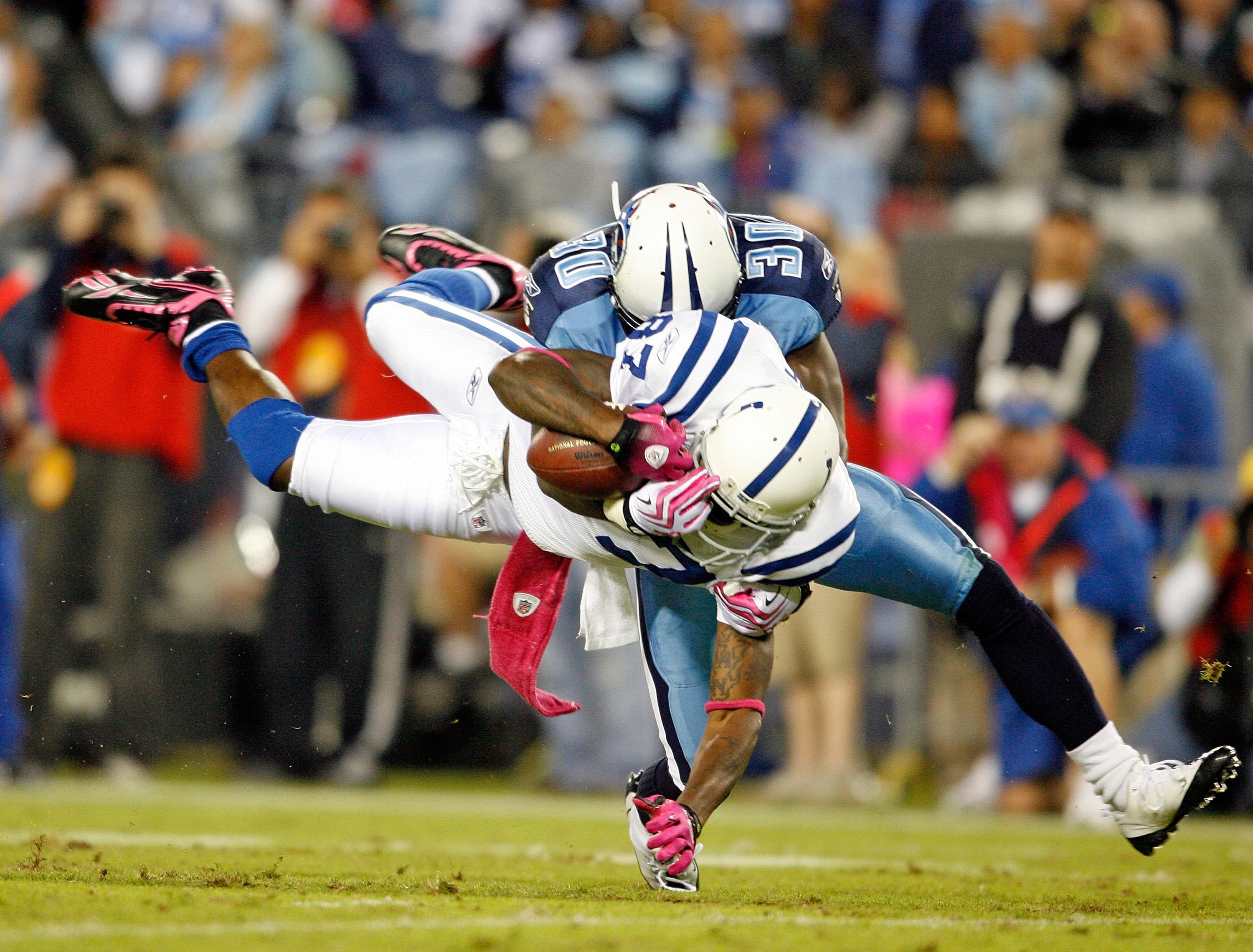 NASHVILLE, TN - OCTOBER 11:  Reggie Wayne #87 of the Indianapolis Colts is tackled by Jason McCourty #30 of the Tennessee Titans during the NFL game at LP Field on October 11, 2009 in Nashville, Tennessee. The Colts defeated the Titans 31-9.  (Photo by An
