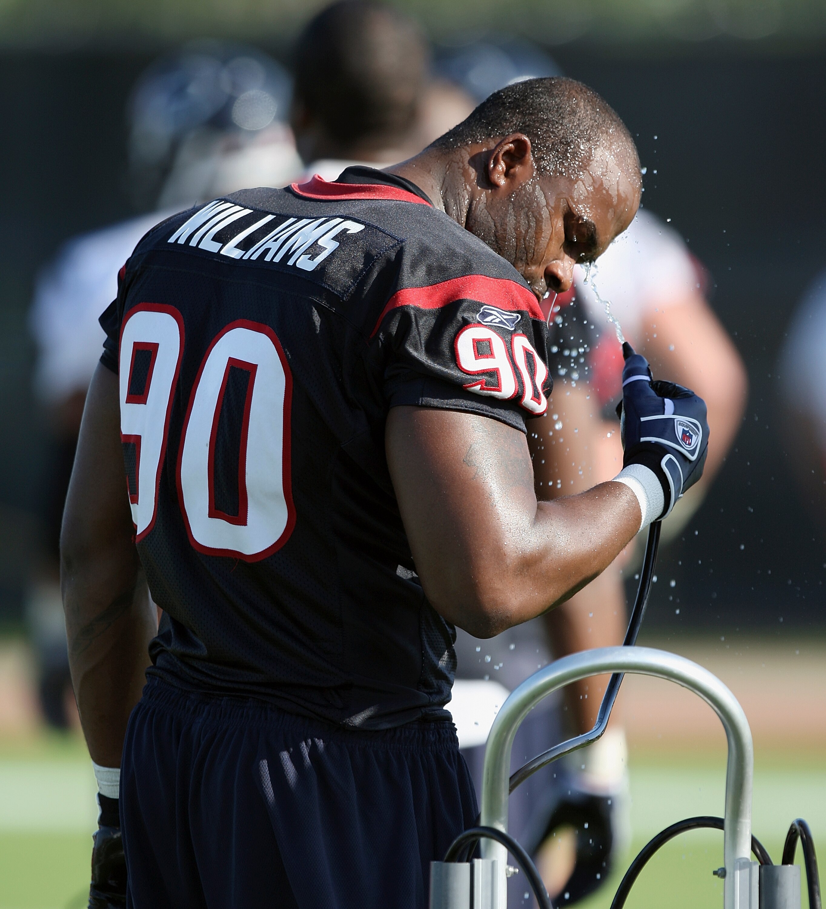 HOUSTON - JULY 30:  Defensive end Mario Williams #90 of the Houston Texans takes a water break to cool off during the team's first NFL traiing camp practice of the season at Reliant Park on July 30, 2010 in Houston, Texas.  (Photo by Bob Levey/Getty Image