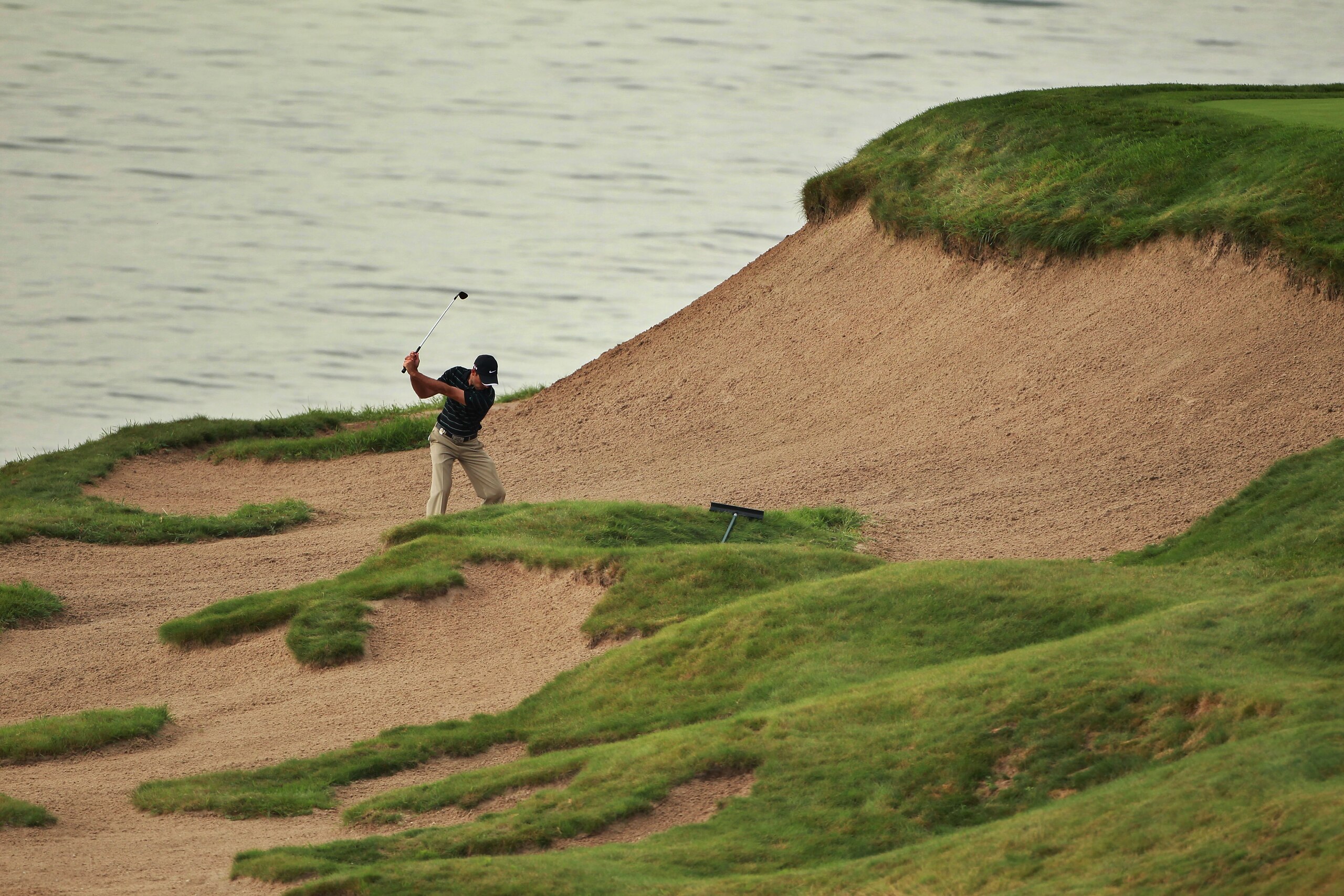 KOHLER, WI - AUGUST 11:  Charl Schwartzel of South Africa plays a bunker shot during a practice round prior to the start of the 92nd PGA Championship on the Straits Course at Whistling Straits on August 11, 2010 in Kohler, Wisconsin.  (Photo by Andrew Red