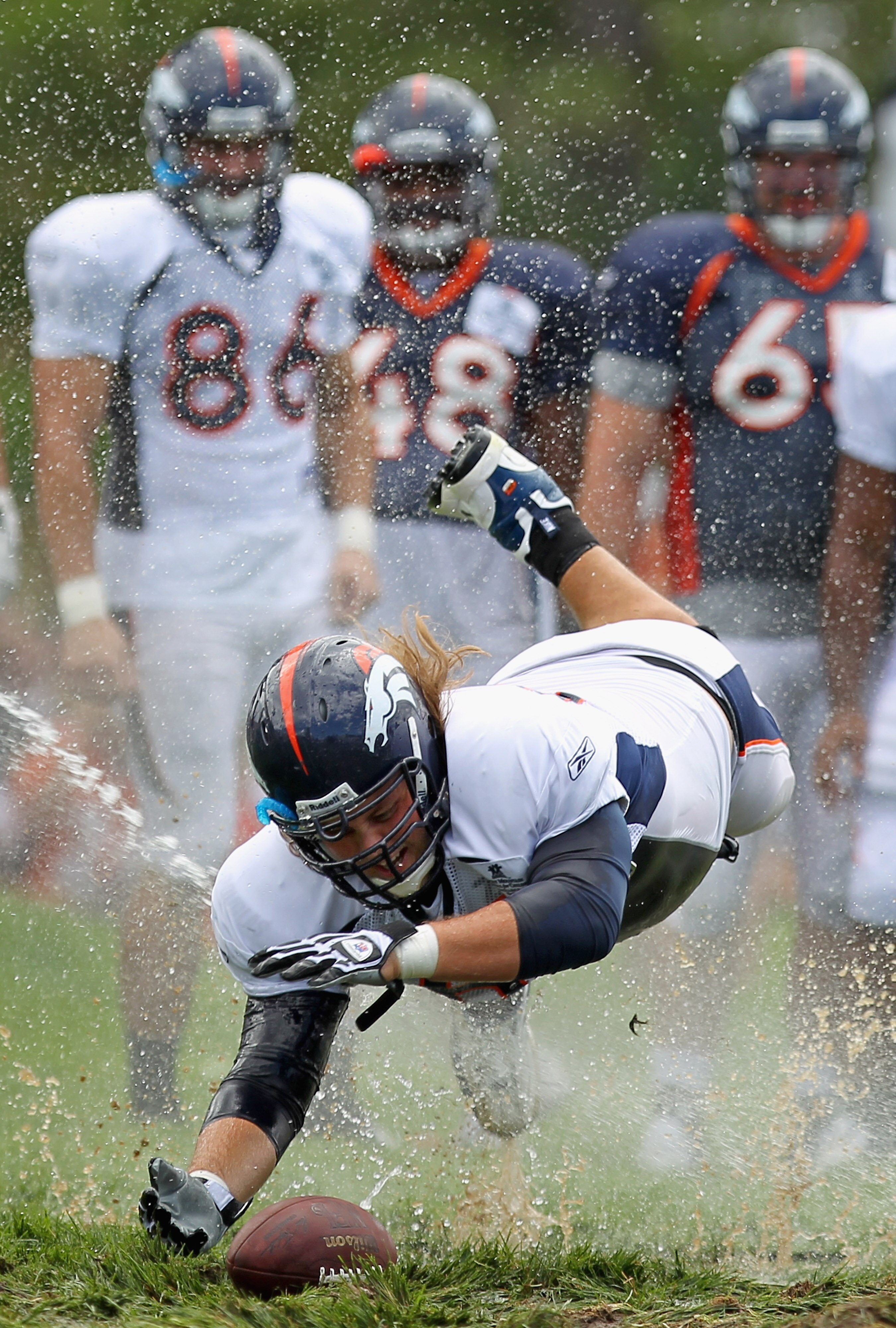 ENGLEWOOD, CO - AUGUST 05:  Offensive lineman Eric Olsen #69 of the Denver Broncos dives for the ball as rookies partake in the slip and slide fumble drill during training camp at Dove Valley on August 5, 2010 in Englewood, Colorado.  (Photo by Doug Pensi