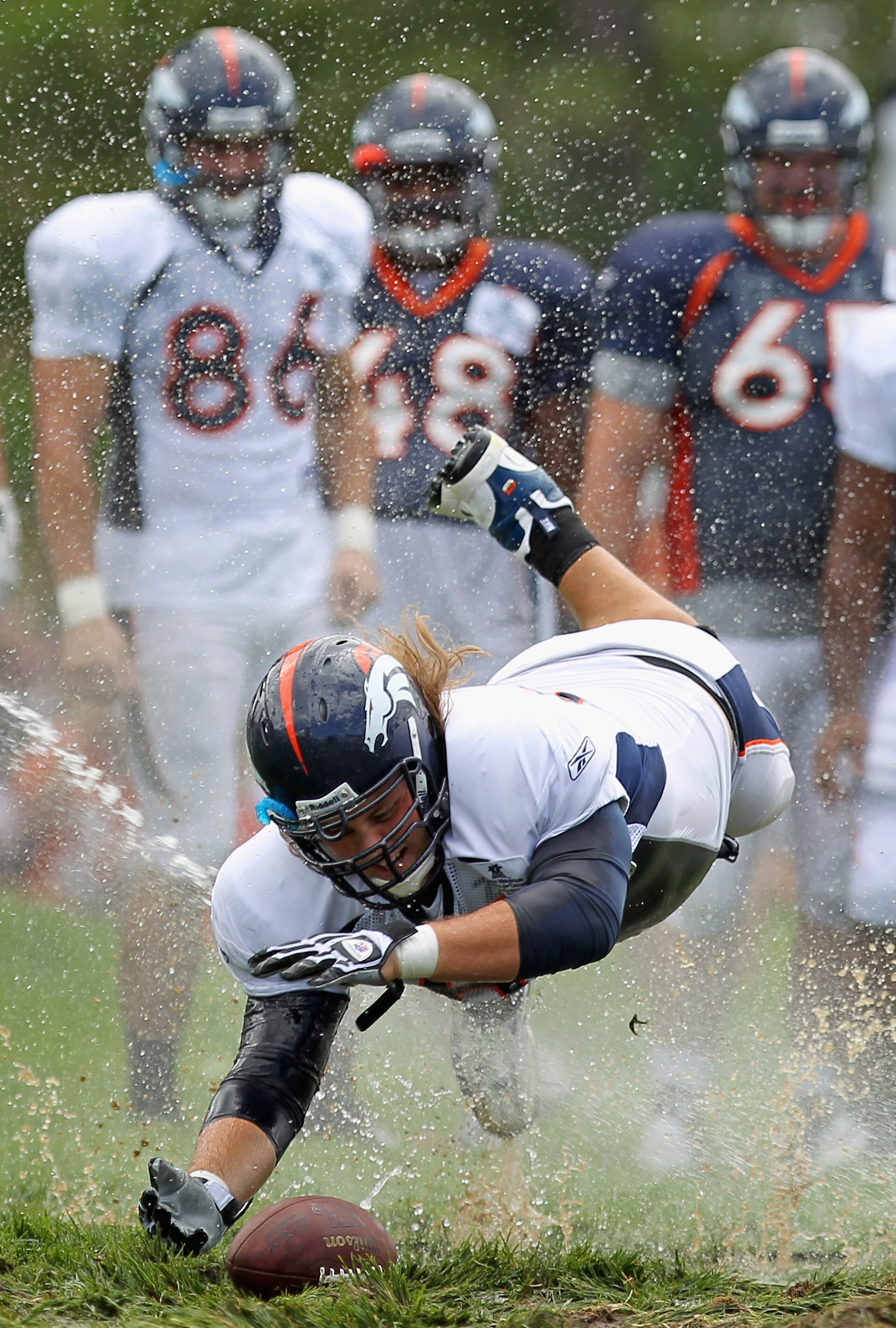ENGLEWOOD, CO - AUGUST 05: Offensive lineman Eric Olsen #69 of the Denver Broncos dives for the ball as rookies partake in the slip and slide fumble drill during training camp at Dove Valley on August 5, 2010 in Englewood, Colorado. (Photo by Doug Pensi ENGLEWOOD, CO - AUGUST 05: Offensive lineman Eric Olsen #69 of the Denver Broncos dives for the ball as rookies partake in the slip and slide fumble drill during training camp at Dove Valley on August 5, 2010 in Englewood, Colorado. (Photo by Doug Pensi