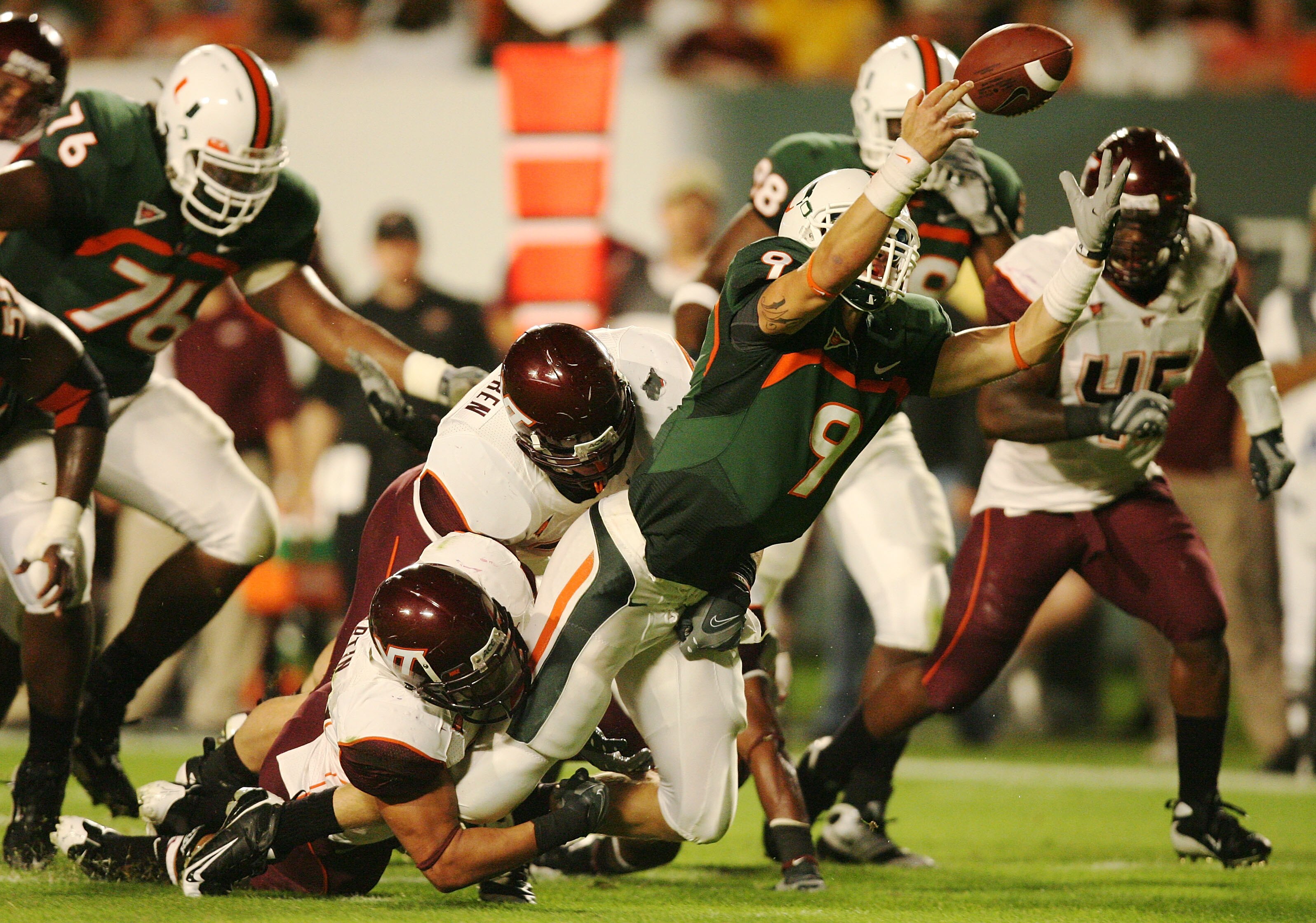 MIAMI - NOVEMBER 13:  Quarterback Robert Marve #9 of the Miami Hurricanes fumbles as he is hit by linebacker Brett Warren #33 and defensive end Orion Martin #90 of the Virginia Tech Hokies at Dolphin Stadium on November 13, 2008 in Miami, Florida.  (Photo