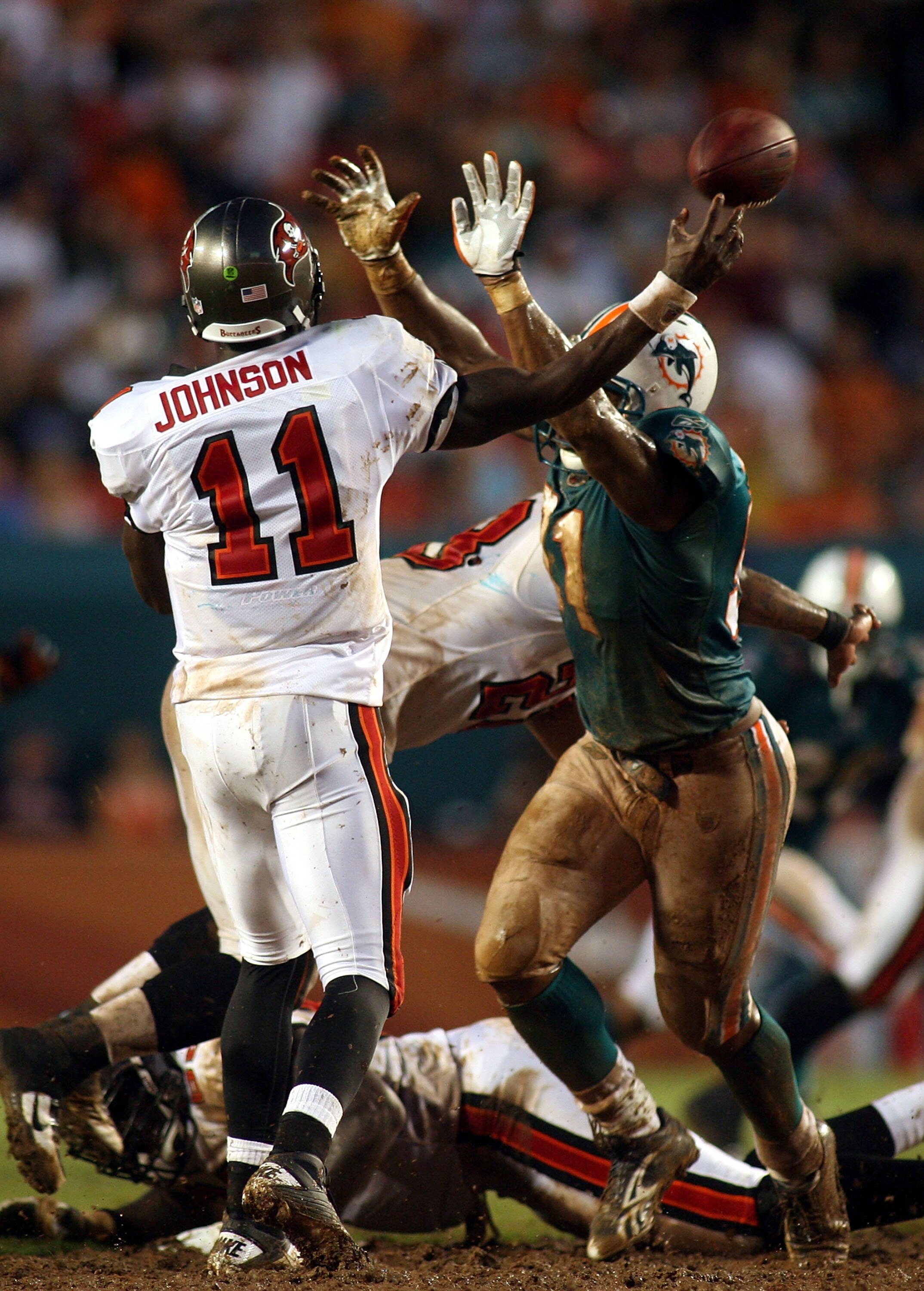 MIAMI - AUGUST 14:  Linebacker Cameron Wake #91 of the Miami Dolphins (R)  pressures Quarterback Josh Johnson #11 of the Tampa Bay Buccaneers during the preseason game at Sun Life Stadium on August 14, 2010 in Miami, Florida.  (Photo by Marc Serota/Getty