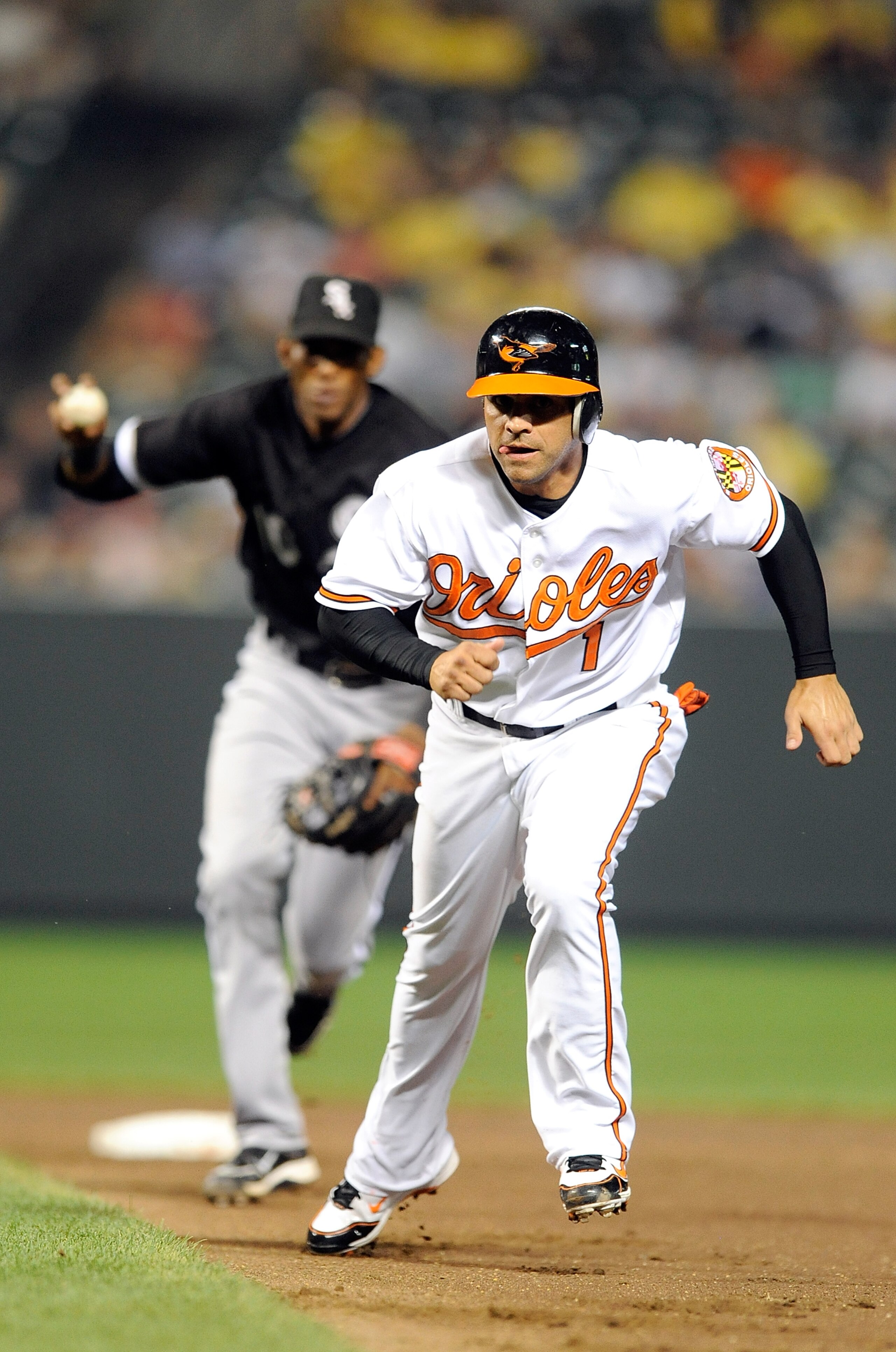 BALTIMORE - AUGUST 09:  Brian Roberts #1 of the Baltimore Orioles is caught in a run-down and tagged out by Alexei Ramirez #10 of the Chicago White Sox at Camden Yards on August 9, 2010 in Baltimore, Maryland. The Orioles won the game 3-2.  (Photo by Greg