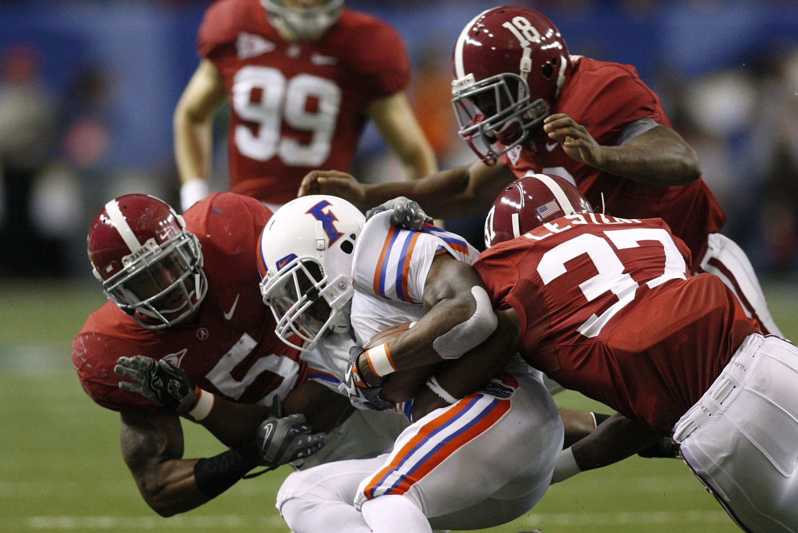 ATLANTA - DECEMBER 5:  Brandon James #25 of the Florida Gators is tackled by Jerrell Harris #5, Robert Lester #37 and Rod Woodson #18 of the Alabama Crimson Tide during the SEC Championship game at Georgia Dome on December 5, 2009 in Atlanta, Georgia.  (P