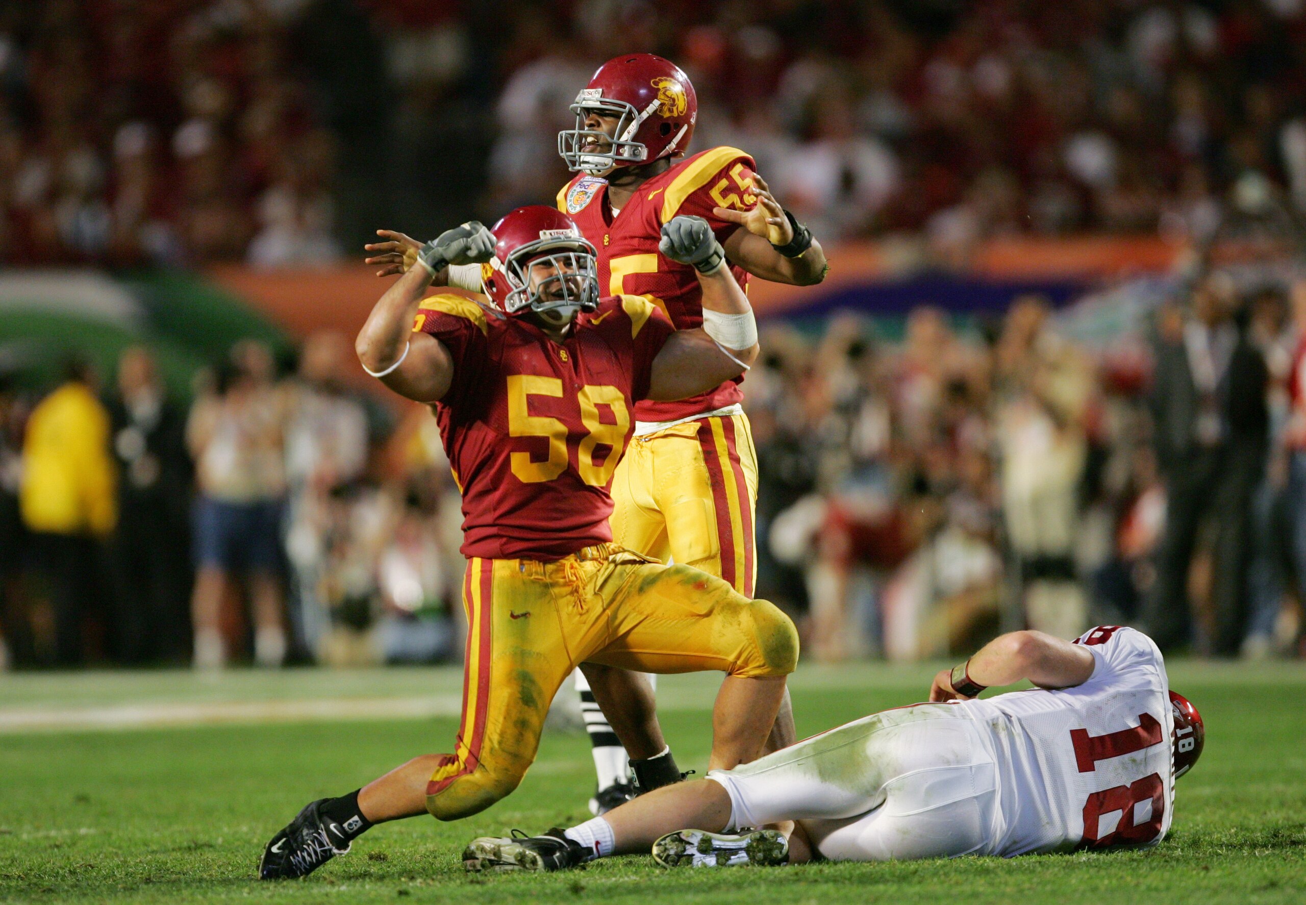 MIAMI - JANUARY 4:  Linebackers Keith Rivers #55 and Lofa Tatupu #58 of the USC Trojans celebrate after sacking Jason White #18 of the Oklahoma Sooners in the third quarter during the FedEx Orange Bowl 2005 National Championship on January 4, 2005 at Pro