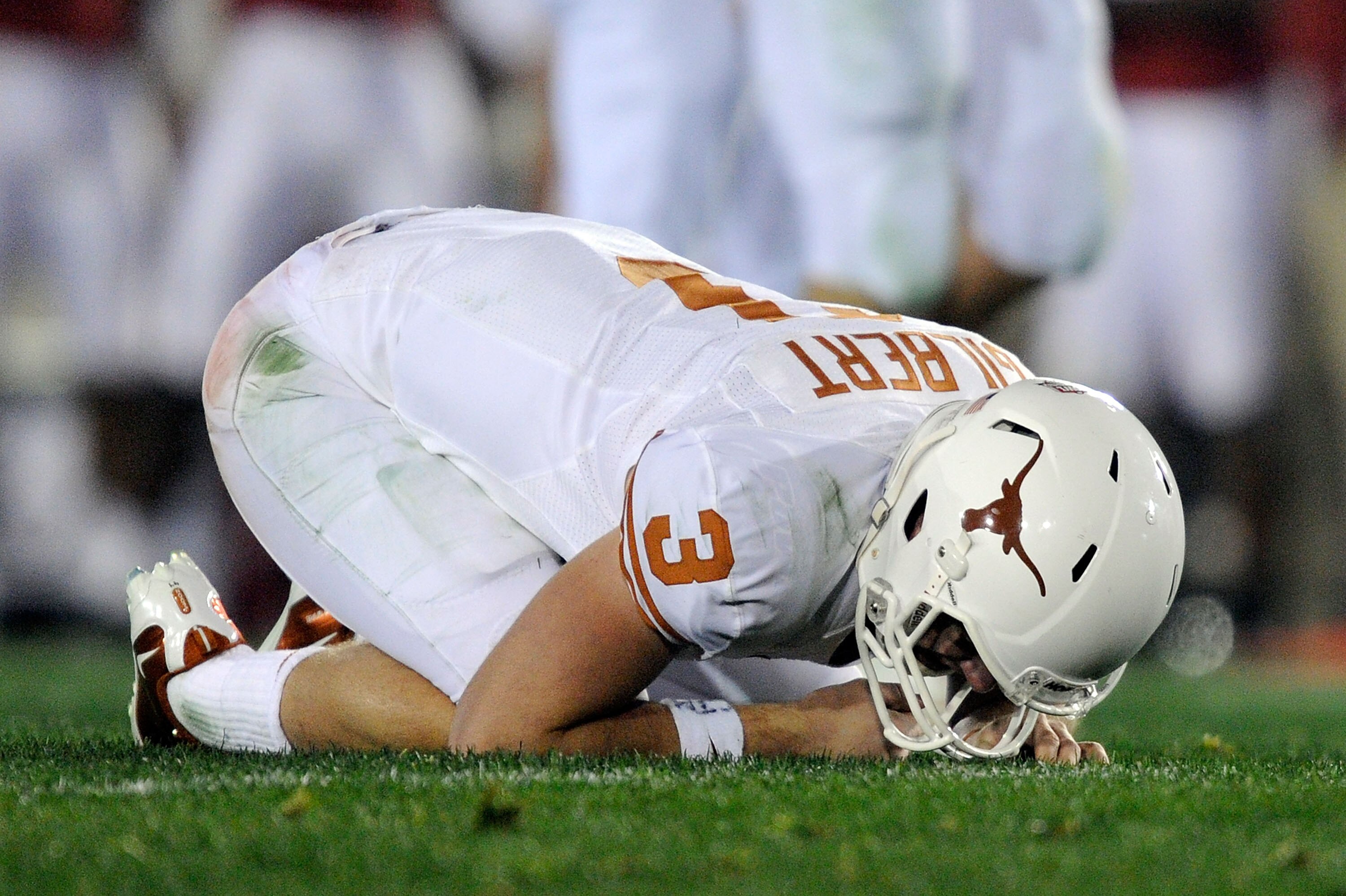PASADENA, CA - JANUARY 07:  Quarterback Garrett Gilbert #3 of the Texas Longhorns kneels on the field after being hit by linebacker Courtney Upshaw #41 of the Alabama Crimson Tide during the Citi BCS National Championship game at the Rose Bowl on January