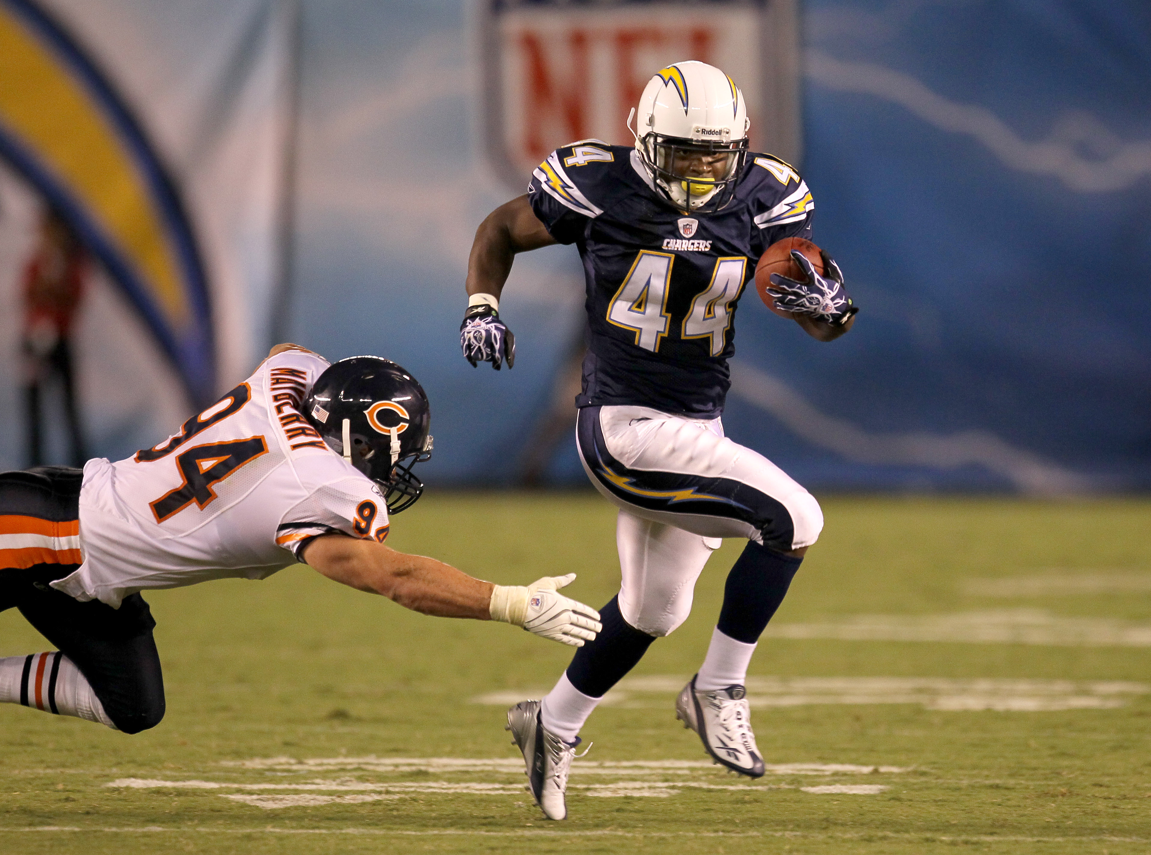 SAN DIEGO - AUGUST 14: Running back Curtis Brinkley #44 of the San Diego Chargers carries the ball past linebacker Matt Mayberry #94 of the Chicago Bears on August 14, 2010 at Qualcomm Stadium in San Diego, California.  The Chargers won 25-10.   (Photo by