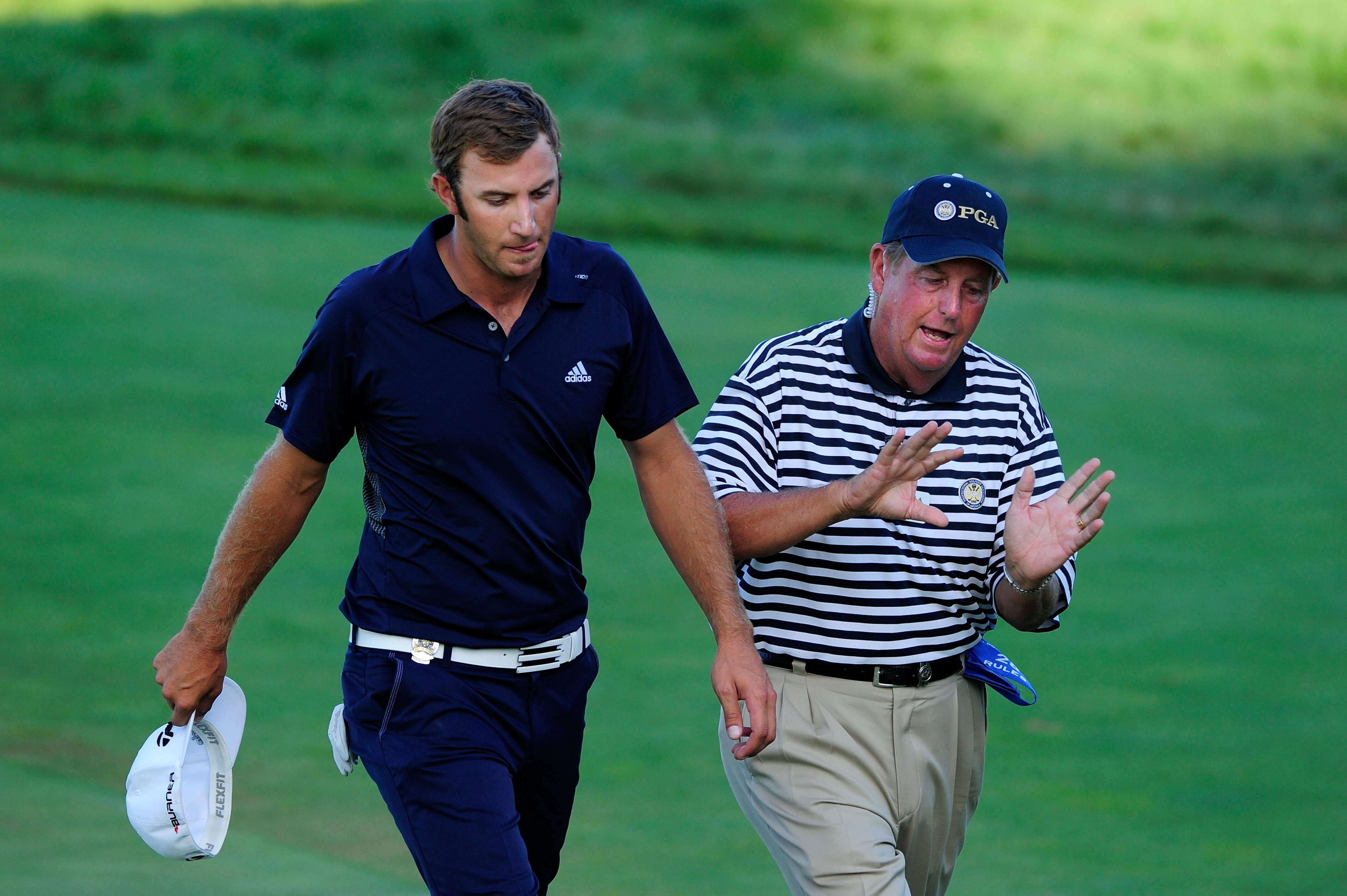KOHLER, WI - AUGUST 15:  A PGA of America rules official chats with Dustin Johnson (R) on the 18th green as Nick Watney (L) looks on during the final round of the 92nd PGA Championship on the Straits Course at Whistling Straits on August 15, 2010 in Kohle