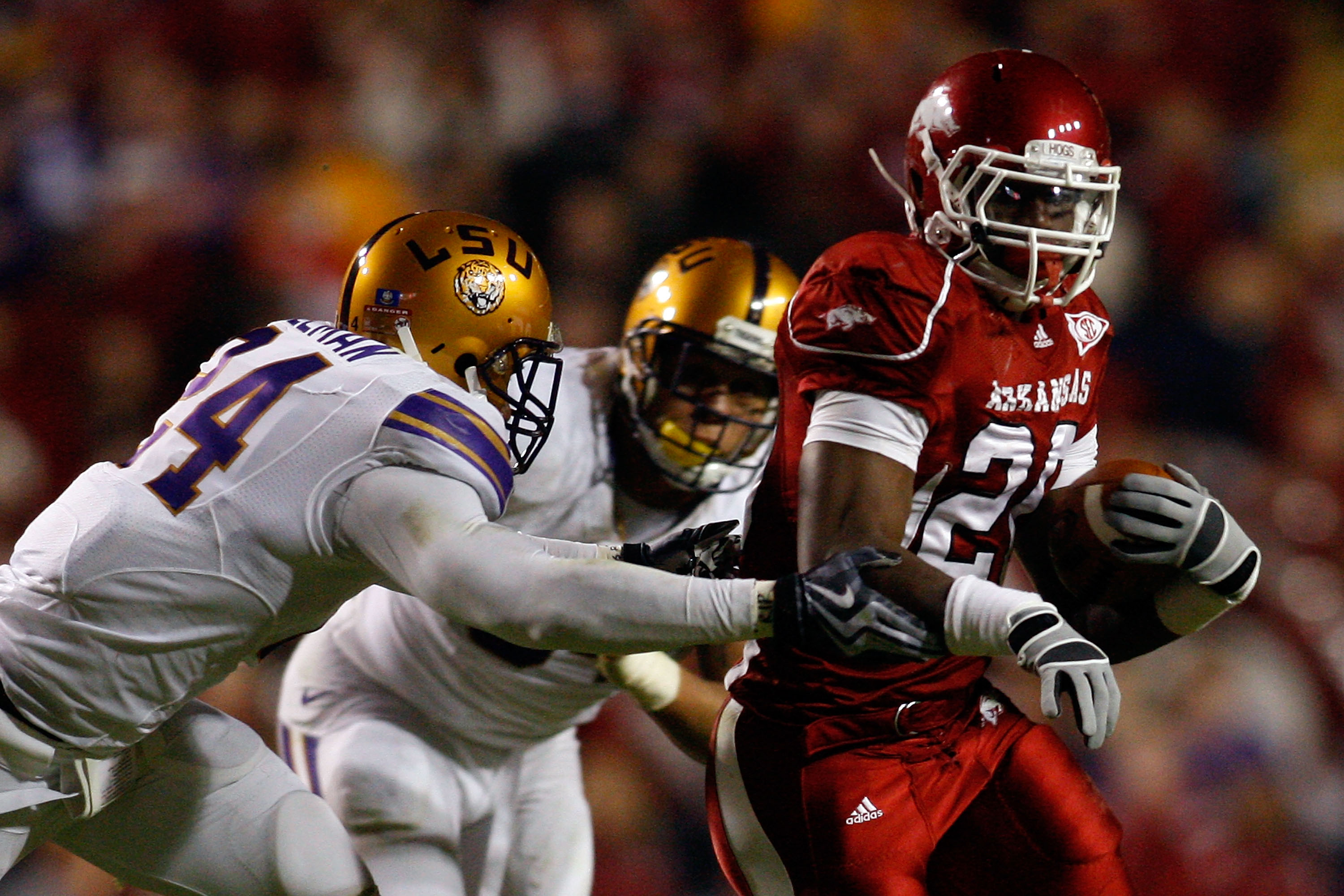 BATON ROUGE, LA - NOVEMBER 28:  Ronnie Wingo Jr. #20 of the Arkansas Razorbacks avoids a tackle by Harry Coleman #24 and Rahim Alem #84 of the LSU Tigers at Tiger Stadium on November 28, 2009 in Baton Rouge, Louisiana.  The Tigers defeated the Razorbacks