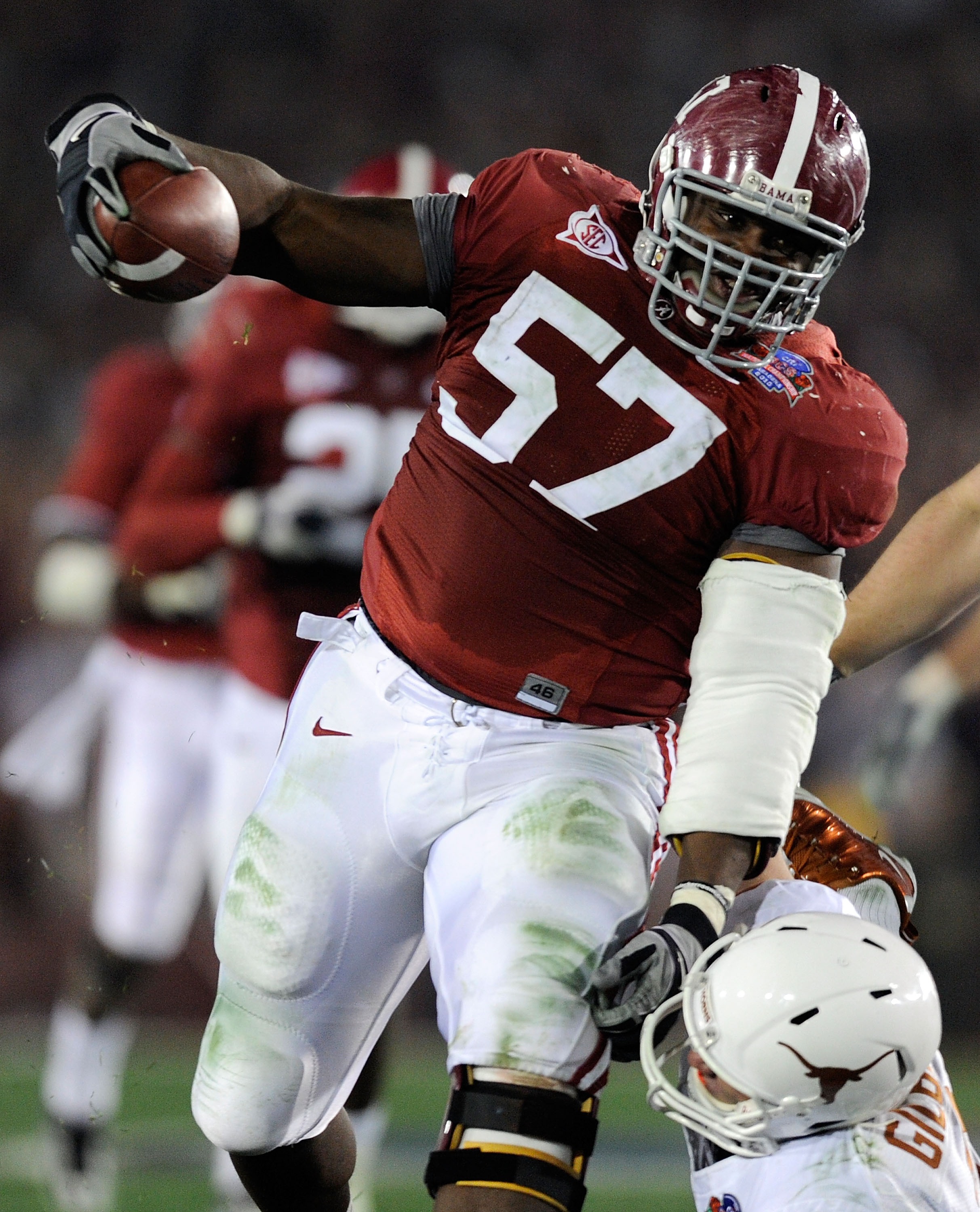 PASADENA, CA - JANUARY 07:  Quarterback Garrett Gilbert #3 of the Texas Longhorns tries to tackle lineman Marcell Dareus #57 of the Alabama Crimson Tide who would score after intercepting the ball during the second quarter of the Citi BCS National Champio