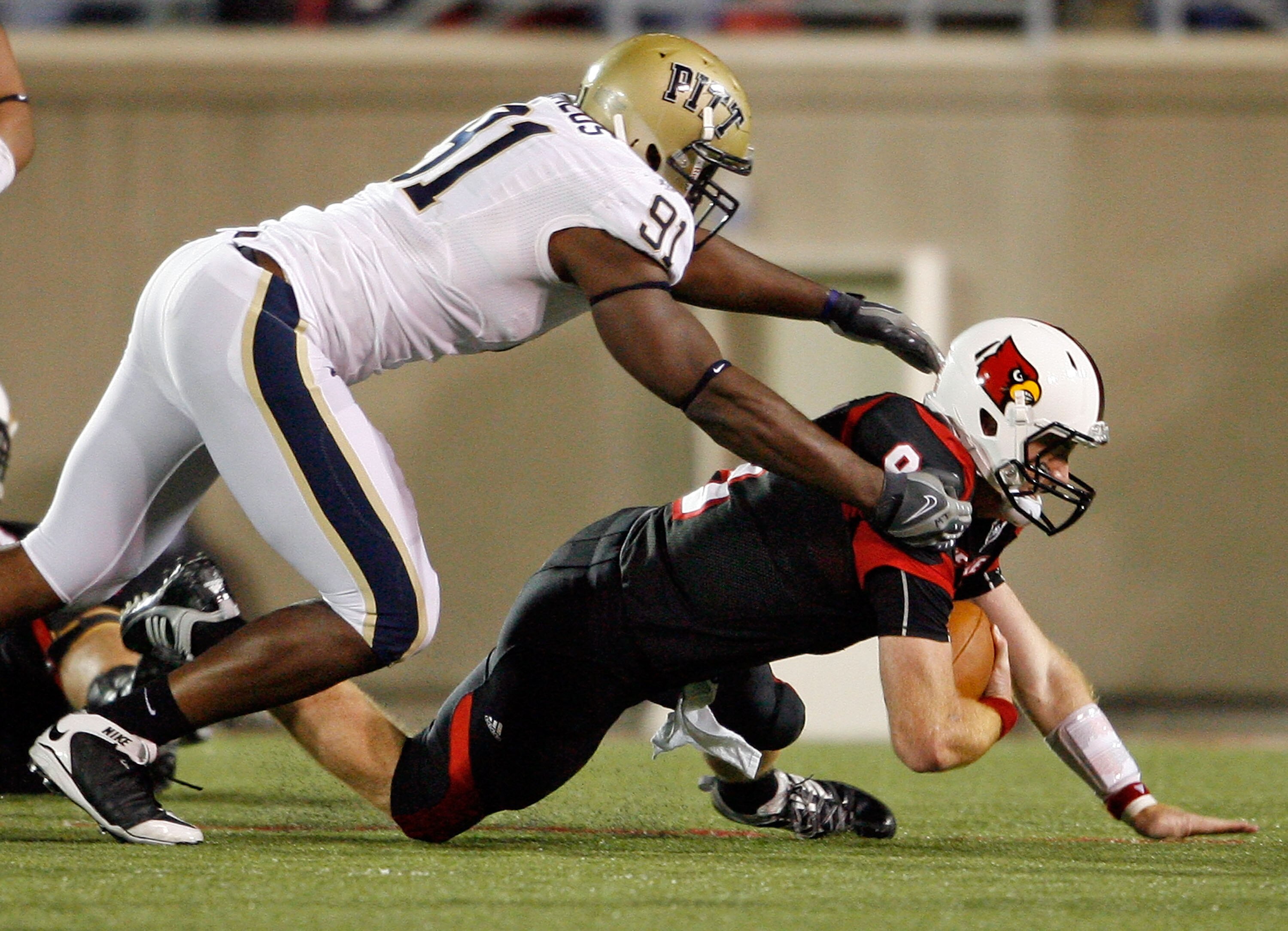 LOUISVILLE, KY - OCTOBER 02:  Adam Froman #9 of the Louisville Cardinals is sacked by Greg Romeus #91  of the Pittsburgh Panthers during the Big East Conference game at Papa John's Cardinal Stadium on October 2, 2009 in Louisville, Kentucky.  (Photo by An