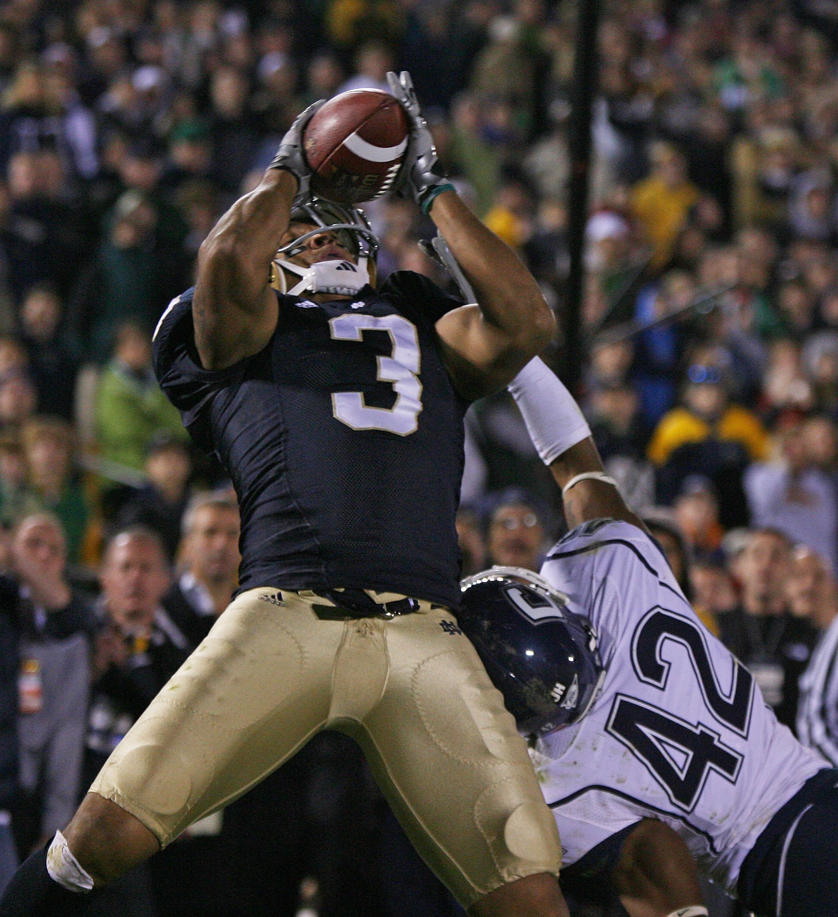 SOUTH BEND, IN - NOVEMBER 21: Michael Floyd #3 of the Notre Dame Fighting Irish catches a pass in overtime as Robert McClain #42 of the Univeristy of Connecticut Huskies defends at Notre Dame Stadium on November 21, 2009 in South Bend, Indiana. Connecticu