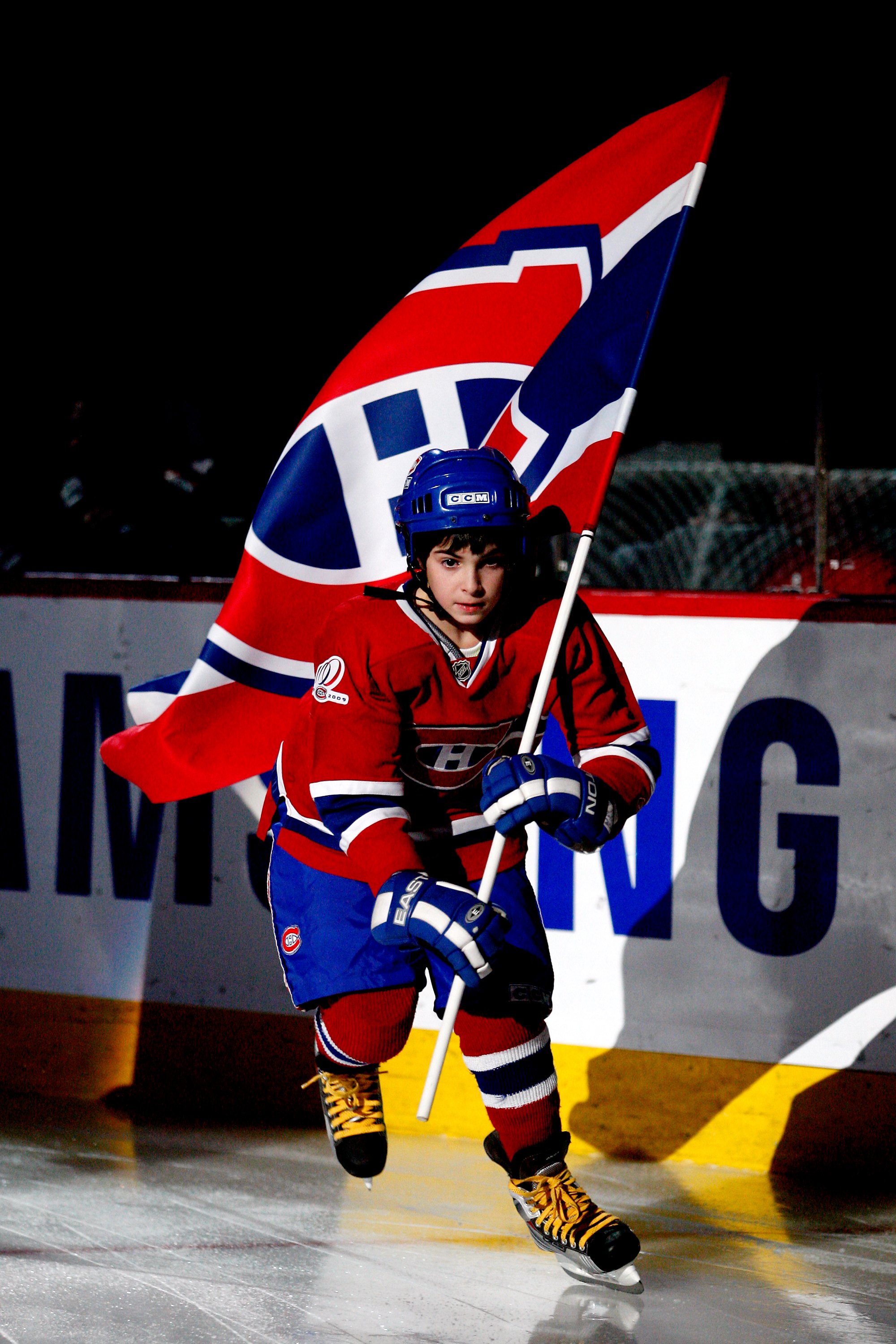 MONTREAL- JANUARY 16:  A flag bearer carries the flag fore the Montreal Canadiens during the NHL game against the Ottawa Senators on January 16, 2010 at the Bell Centre in Montreal, Quebec, Canada.  The Senators defeated the Canadiens 4-2.  (Photo by Rich