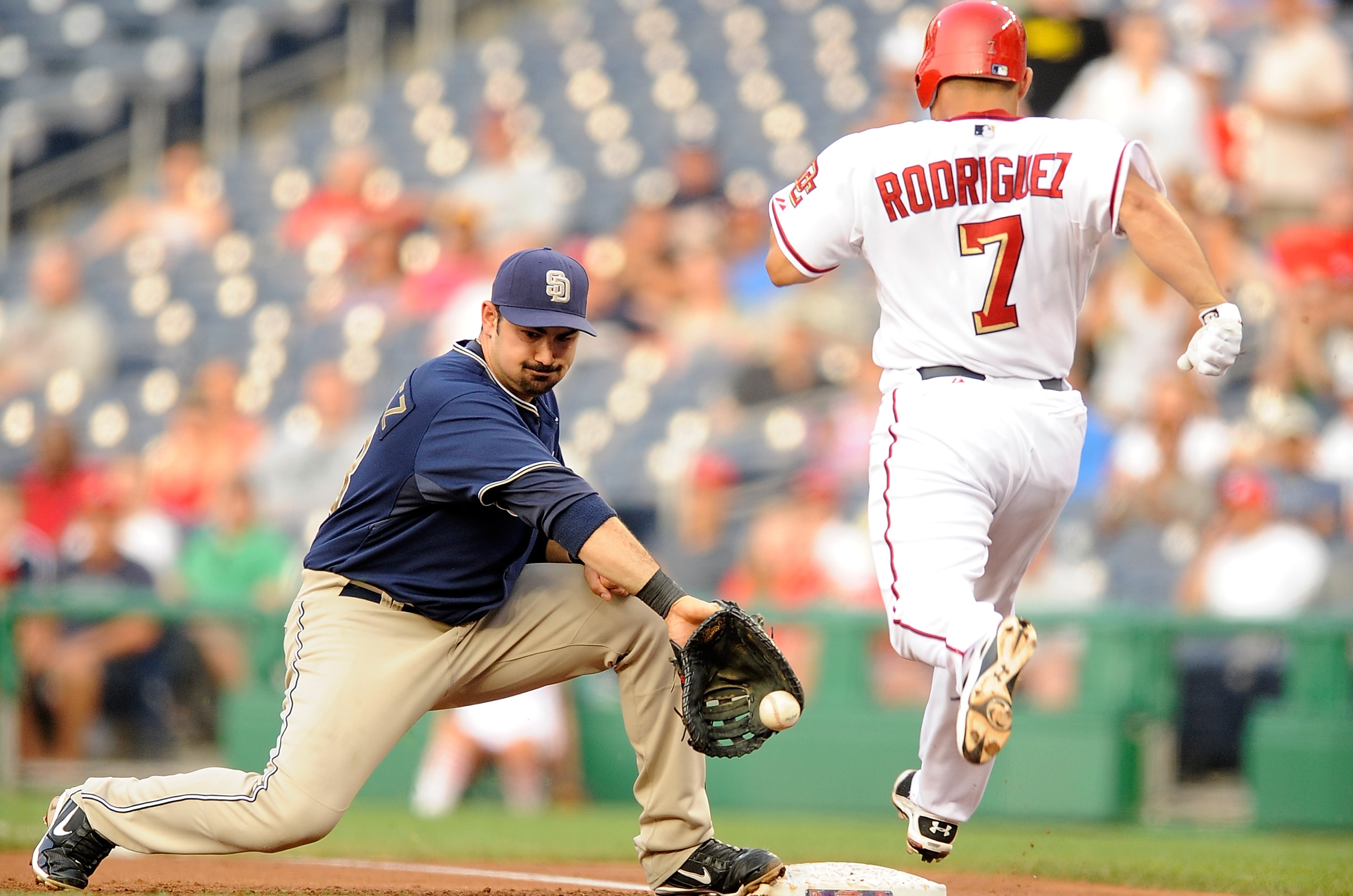 WASHINGTON - JULY 06:  Ivan Rodriguez #7 of the Washington Nationals is safe at first base ahead of the throw to Adrian Gonzalez #23 of the San Diego Padres at Nationals Park on July 6, 2010 in Washington, DC.  The Nationals won the game 6-5.  (Photo by G