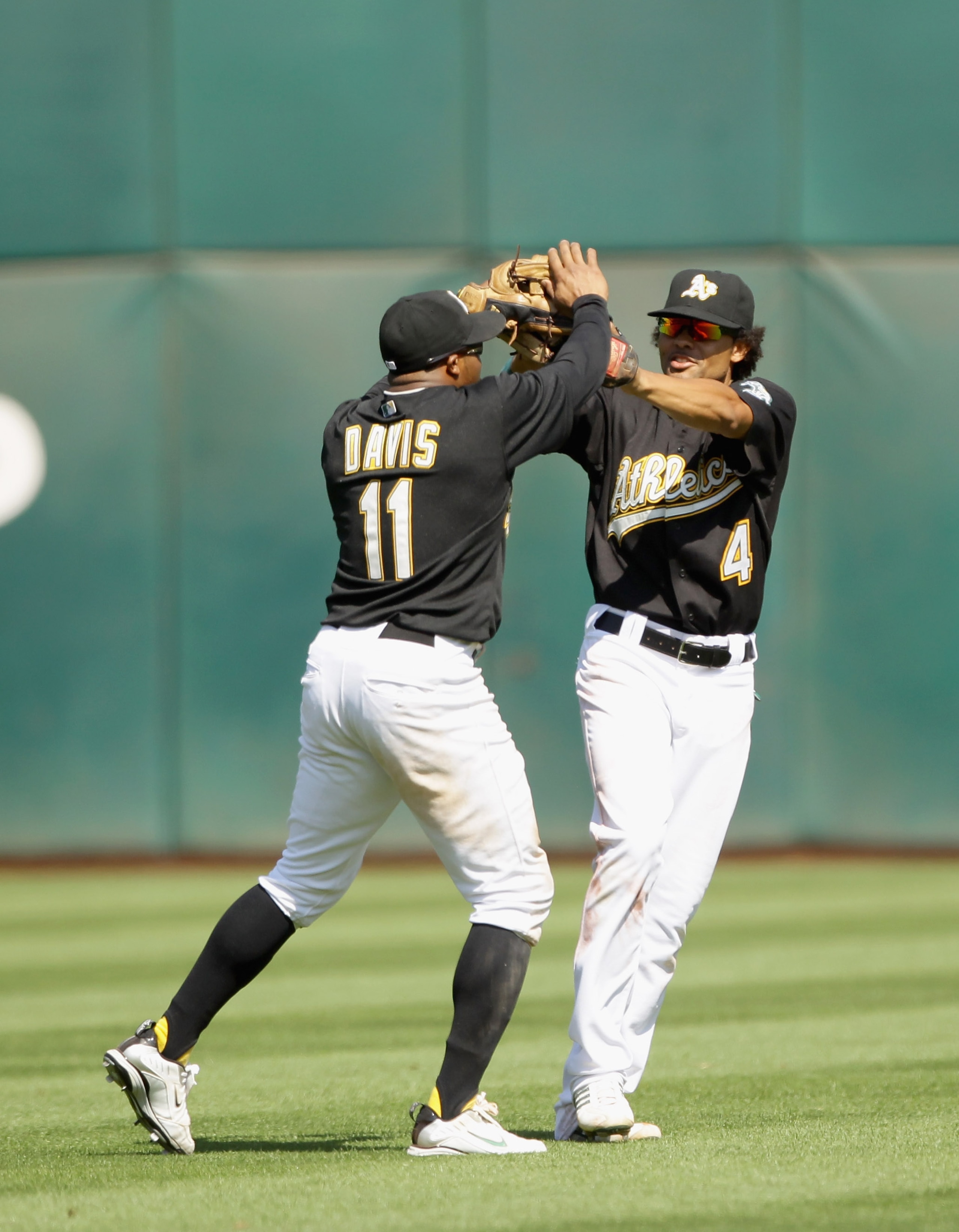 OAKLAND, CA - AUGUST 07:  Rajai Davis #11 and Coco Crisp #4 of the Oakland Athletics celebrate after they beat the Texas Rangers at the Oakland-Alameda County Coliseum on August 7, 2010 in Oakland, California.  (Photo by Ezra Shaw/Getty Images)