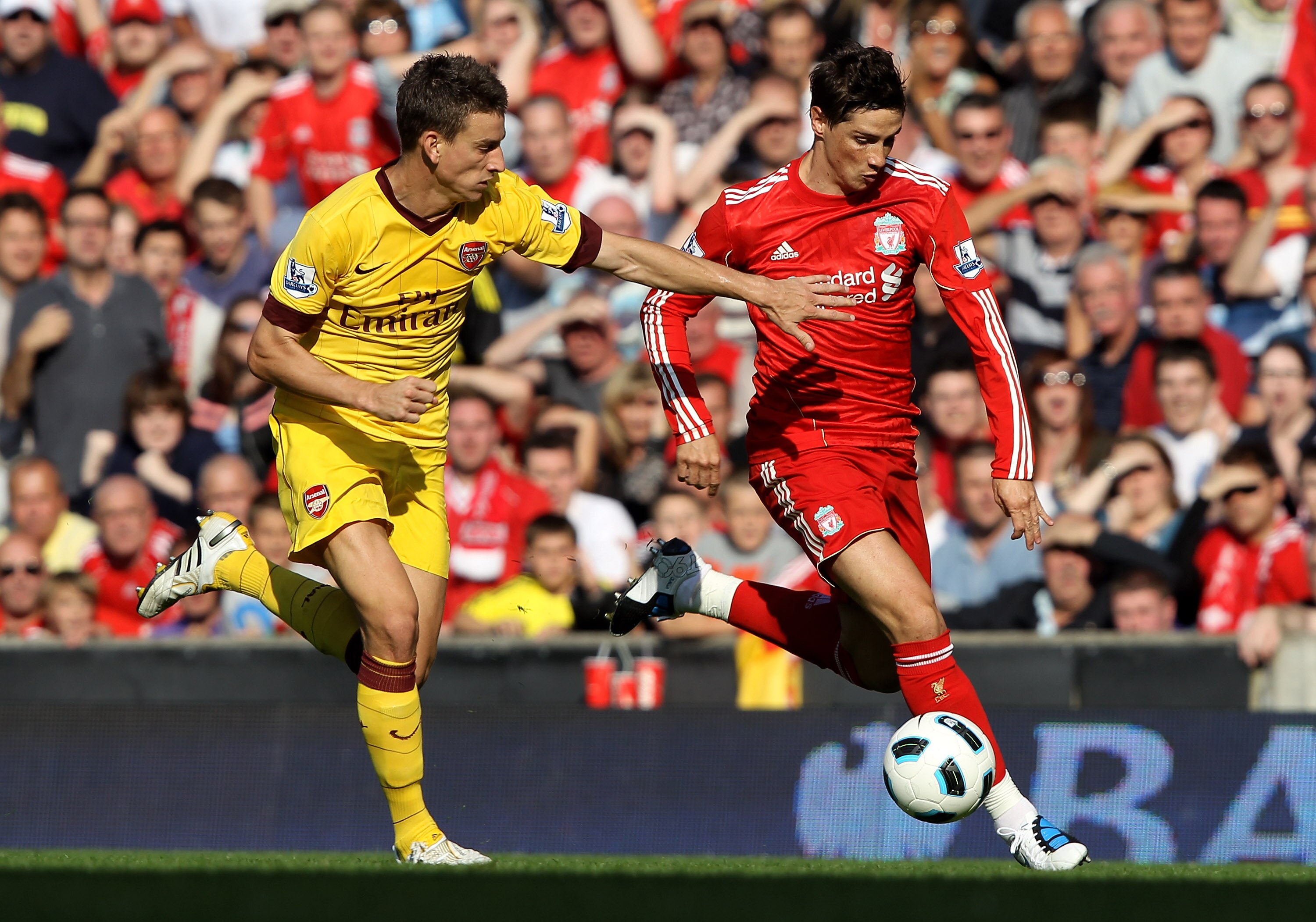 LIVERPOOL, ENGLAND - AUGUST 15:  Fernando Torres of Liverpool tussles for posession with Laurent Koscielny of Arsenal during the Barclays Premier League match between Liverpool and Arsenal at Anfield on August 15, 2010 in Liverpool, England.  (Photo by Cl