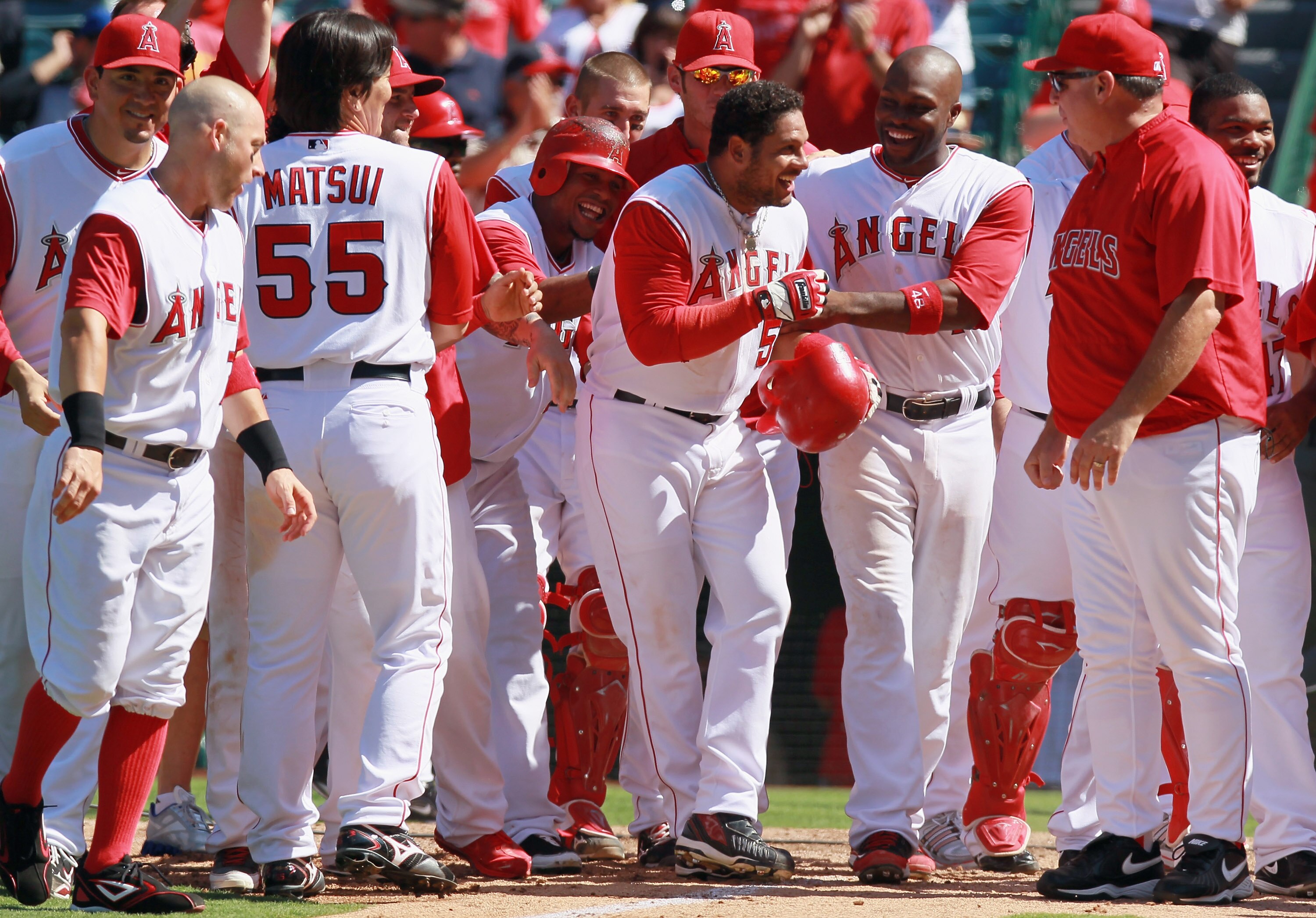 ANAHEIM, CA - AUGUST 11:  Bobby Abreu (4th from right) #53 of the Los Angeles Angels of Anaheim is congratulated by his teammates at home plate after hitting the game winning walk-off solo home run in the 10th inning gainst the Kansas City Royals at Angel