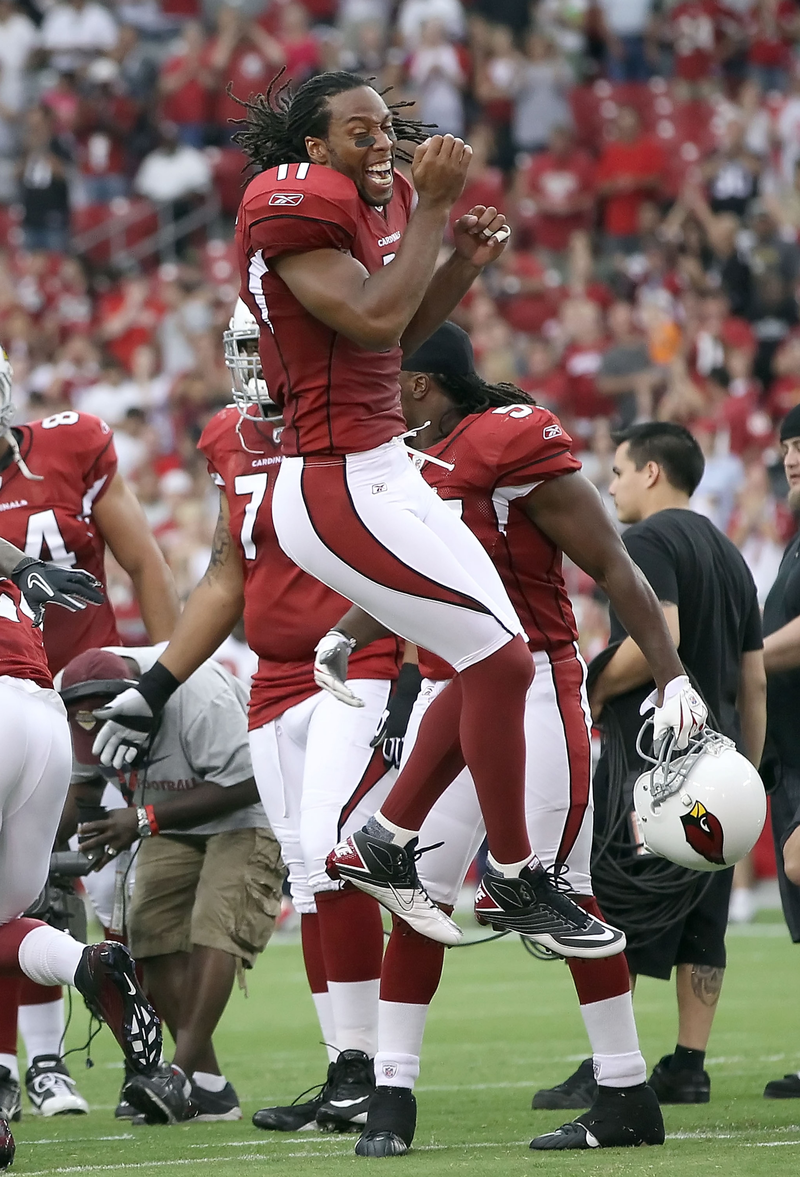 GLENDALE, AZ - AUGUST 14:  Wide receiver Larry Fitzgerald #11 of the Arizona Cardinals greets teammates before the preseason NFL game against the Houston Texans at the University of Phoenix Stadium on August 14, 2010 in Glendale, Arizona.  The Cardinals d