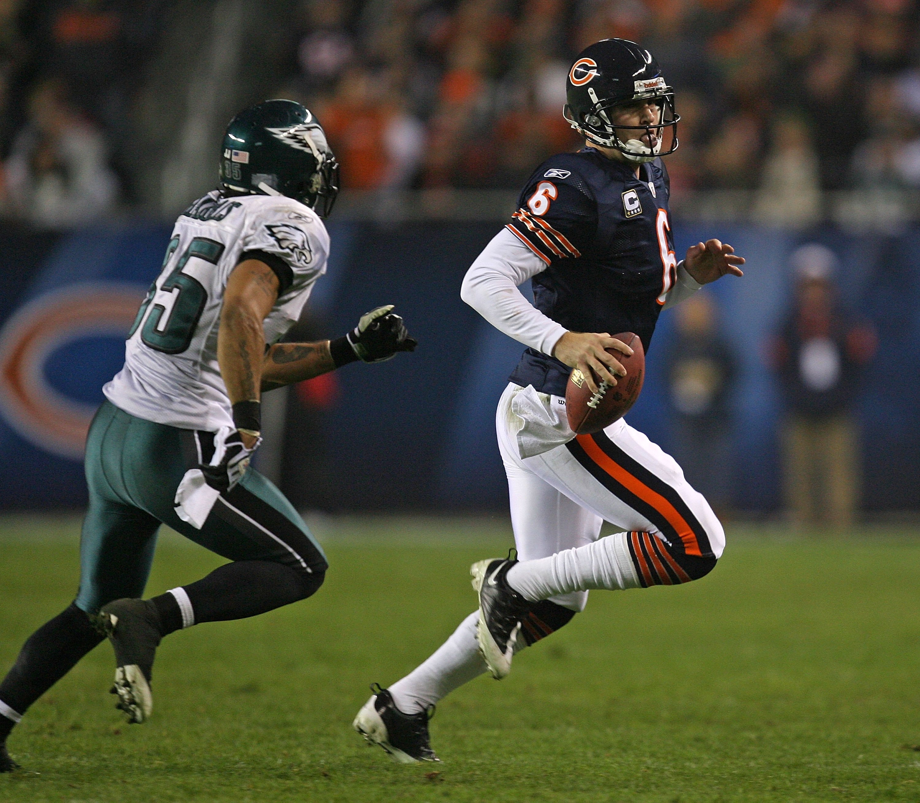 CHICAGO - NOVEMBER 22: Jay Cutler #6 of the Chicago Bears runs for a first down while being chased by Macho Harris #35 of the Philadelphia Eagles at Soldier Field on November 22, 2009 in Chicago, Illinois. The Eagles defeated the Bears 24-20. (Photo by Jo