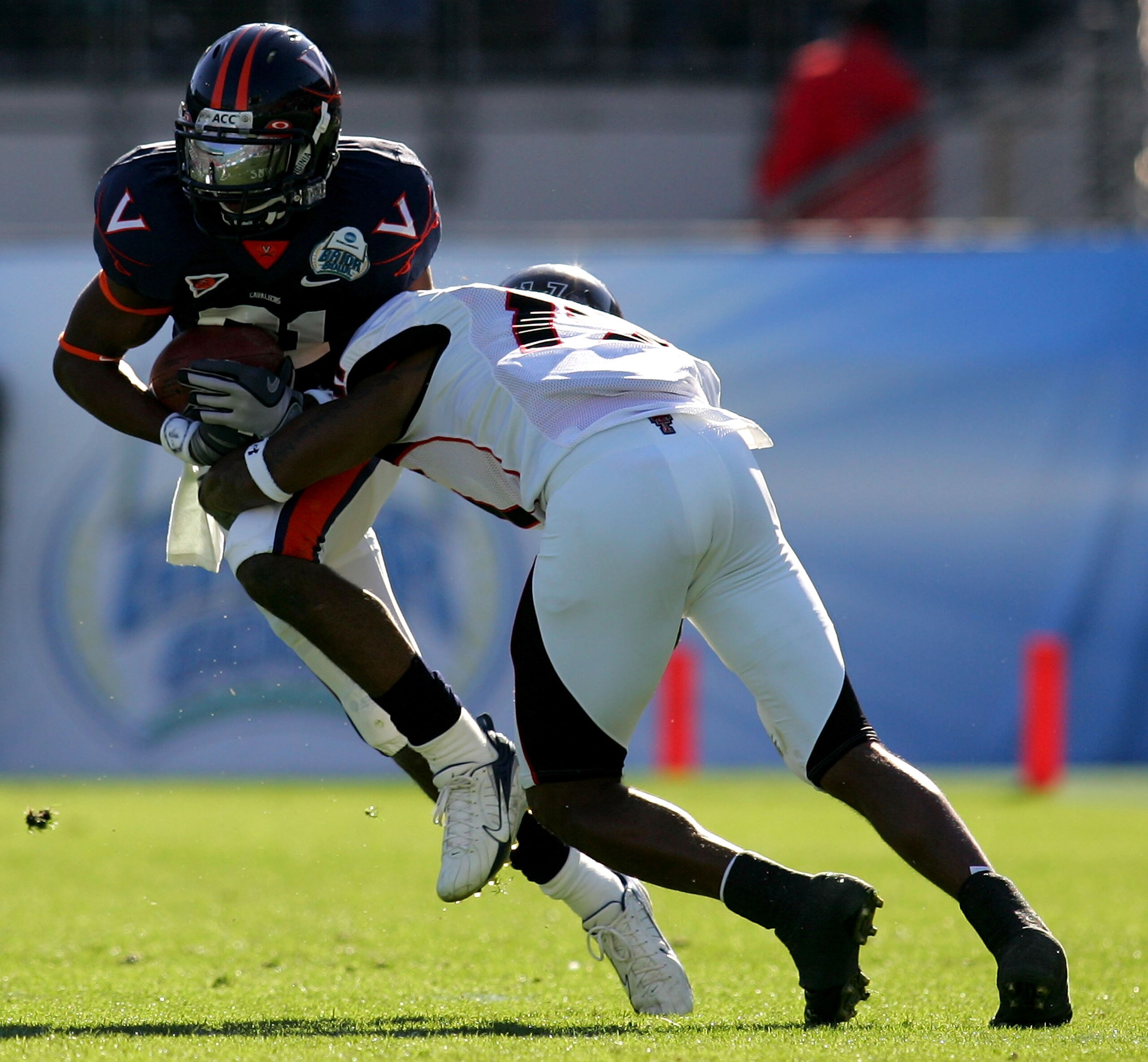 JACKSONVILLE, FL - JANUARY 01: Dontrelle Inman  #81 of the Virginia Cavaliers is tackled by Chris Parker #17 of the Texas Tech Red Raiders during the Gator Bowl at Jacksonville Municipal Stadium on January 1, 2008 in Jacksonville, Florida.  (Photo by Sam