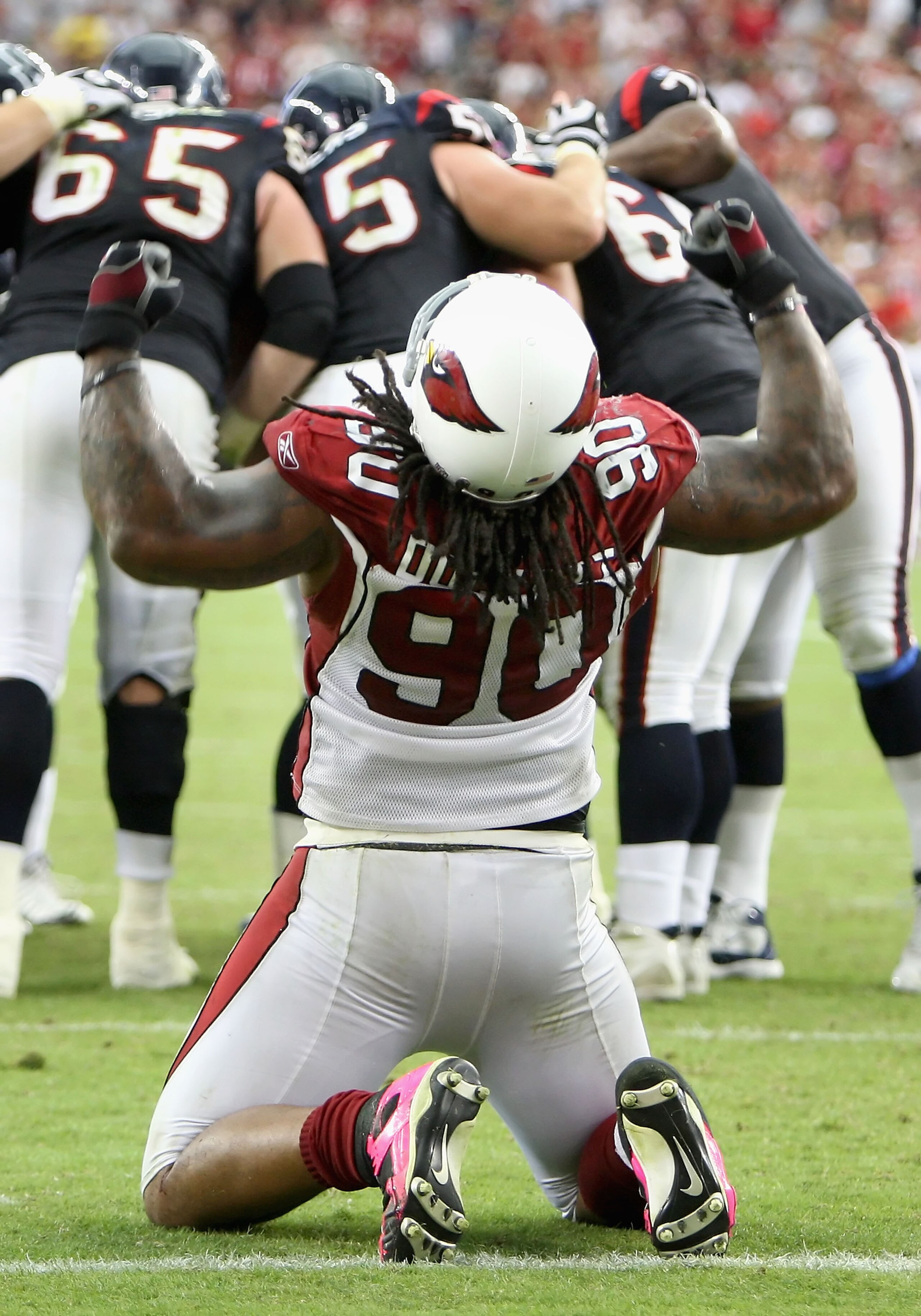GLENDALE, AZ - OCTOBER 11: Defensive tackle Darnell Dockett #90 of the Arizona Cardinals attempts to pump up the crowd as the Houston Texans huddle up during the final moments of the NFL game at the Universtity of Phoenix Stadium on October 11, 2009 in Gl