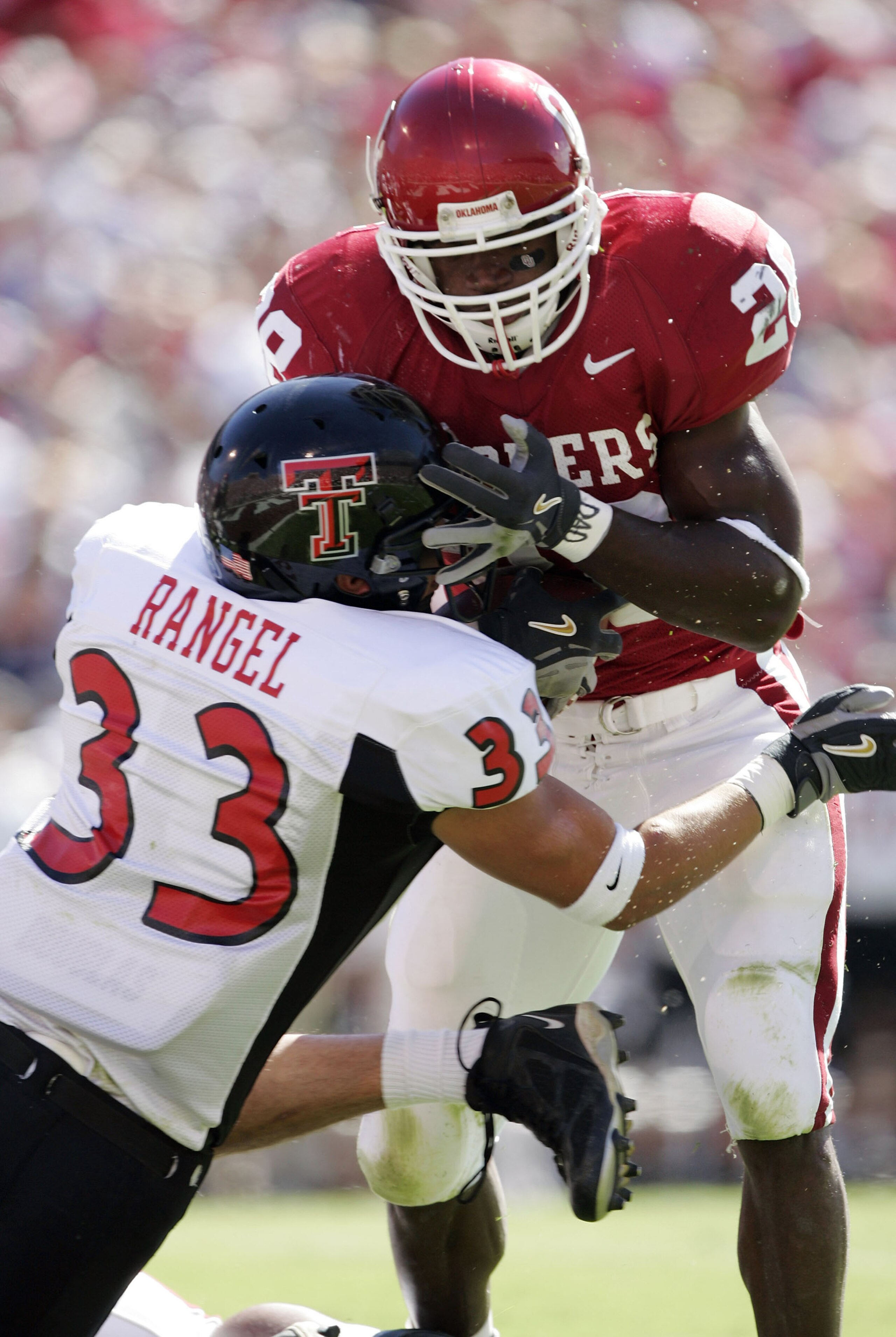 NORMAN, OK - OCTOBER 2:  Running back Adrian Peterson #28 of the Oklahoma Sooners pushes away safety Josh Rangel #33 of the Texas Tech Red Raiders for a touchdown in the first quarter on October 2, 2004 at Memorial Stadium in Norman, Oklahoma. Oklahoma wo