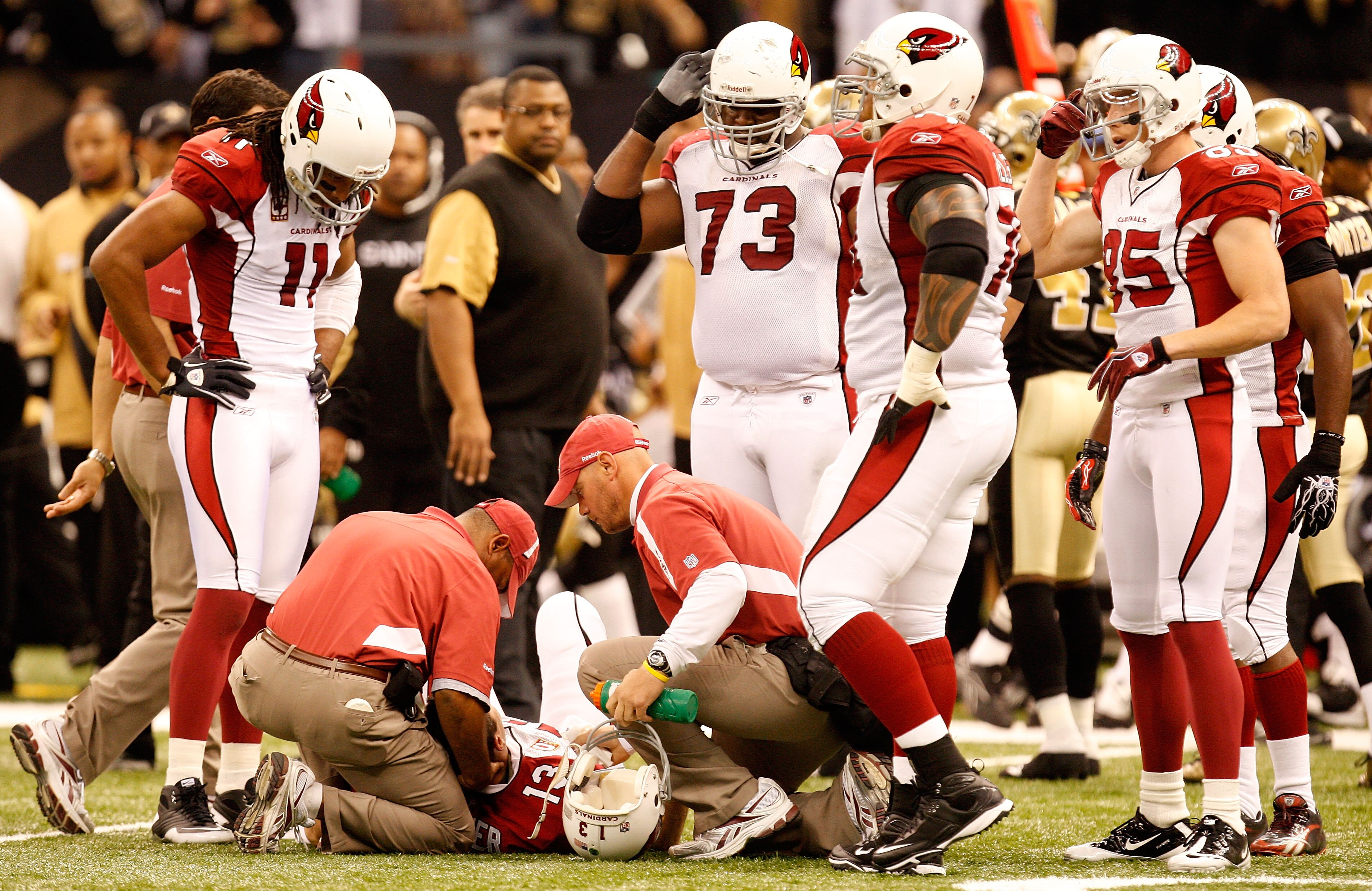 NEW ORLEANS - JANUARY 16:  Quarterback Kurt Warner #13 of the Arizona Cardinals lies on the field as he is tended to by the medical staff and teammates after he took a hard hit in the first half against the New Orleans Saints during the NFC Divisional Pla