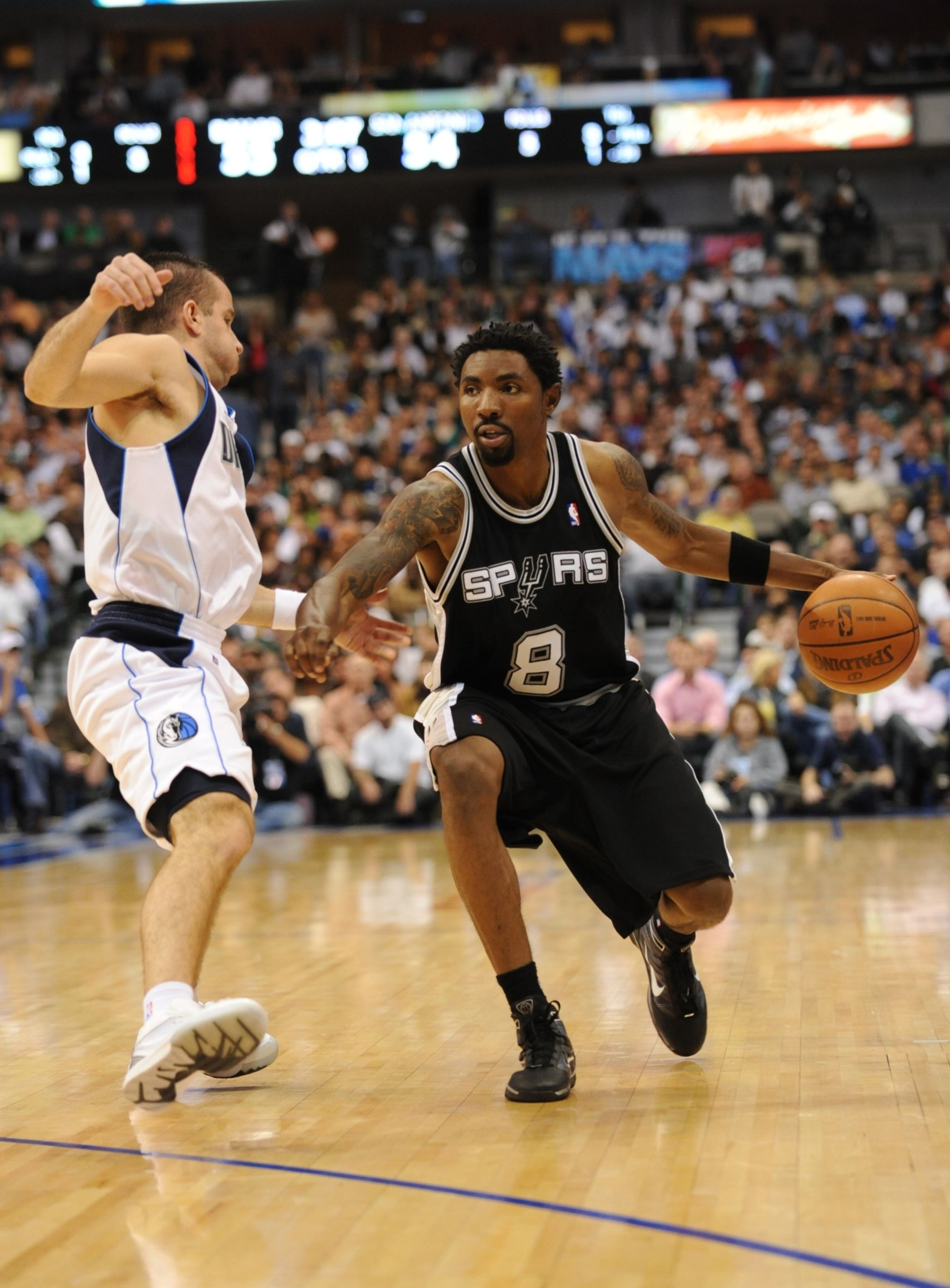 DALLAS - NOVEMBER 18:  Roger Mason Jr. #8 of the San Antonio Spurs moves the ball against Jose Barea #11 of the Dallas Mavericks during the game at American Airlines Center on November 18, 2009 in Dallas, Texas. NOTE TO USER: User expressly acknowledges a