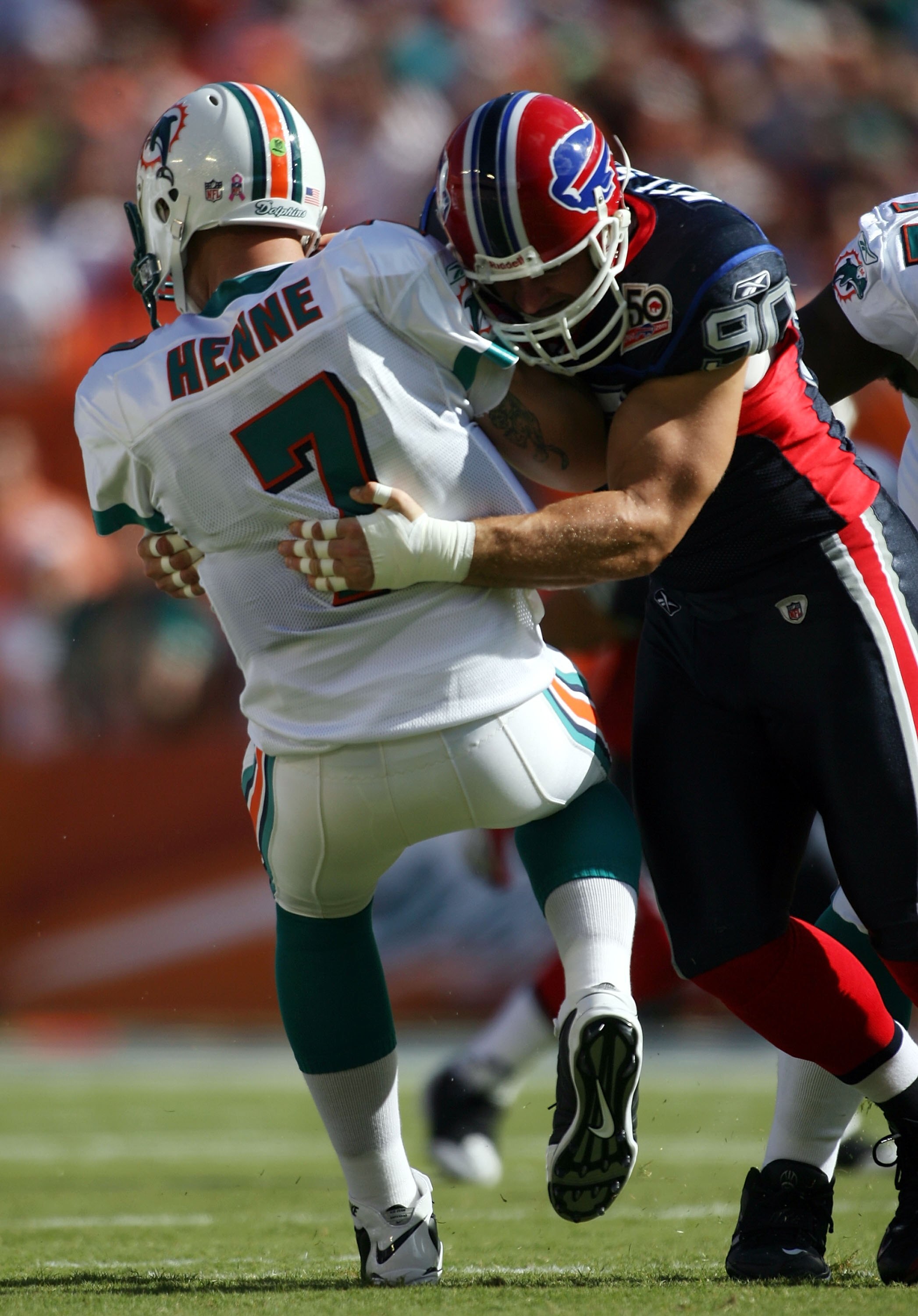 MIAMI - OCTOBER 04:  Quarterback Chad Henne #7 of the Miami Dolphins is sacked by defensive end Chris Kelsay #90 of the Buffalo Bills at Land Shark Stadium on October 4, 2009 in Miami, Florida.  Miami defeated Buffalo 31-30. (Photo by Marc Serota/Getty Im