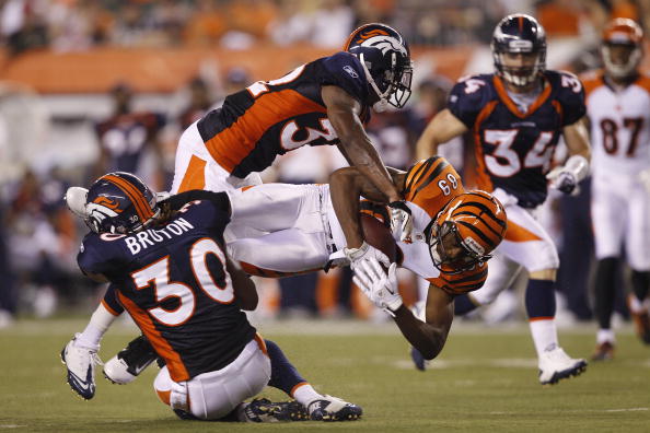 CINCINNATI, OH - AUGUST 15: Jerome Simpson #89 of the Cincinnati Bengals gets tackled after catching a pass by Perrish Cox #32 and David Bruton #30 of the Denver Broncos during a preseason game at Paul Brown Stadium on August 15, 2010 in Cincinnati, Ohio.
