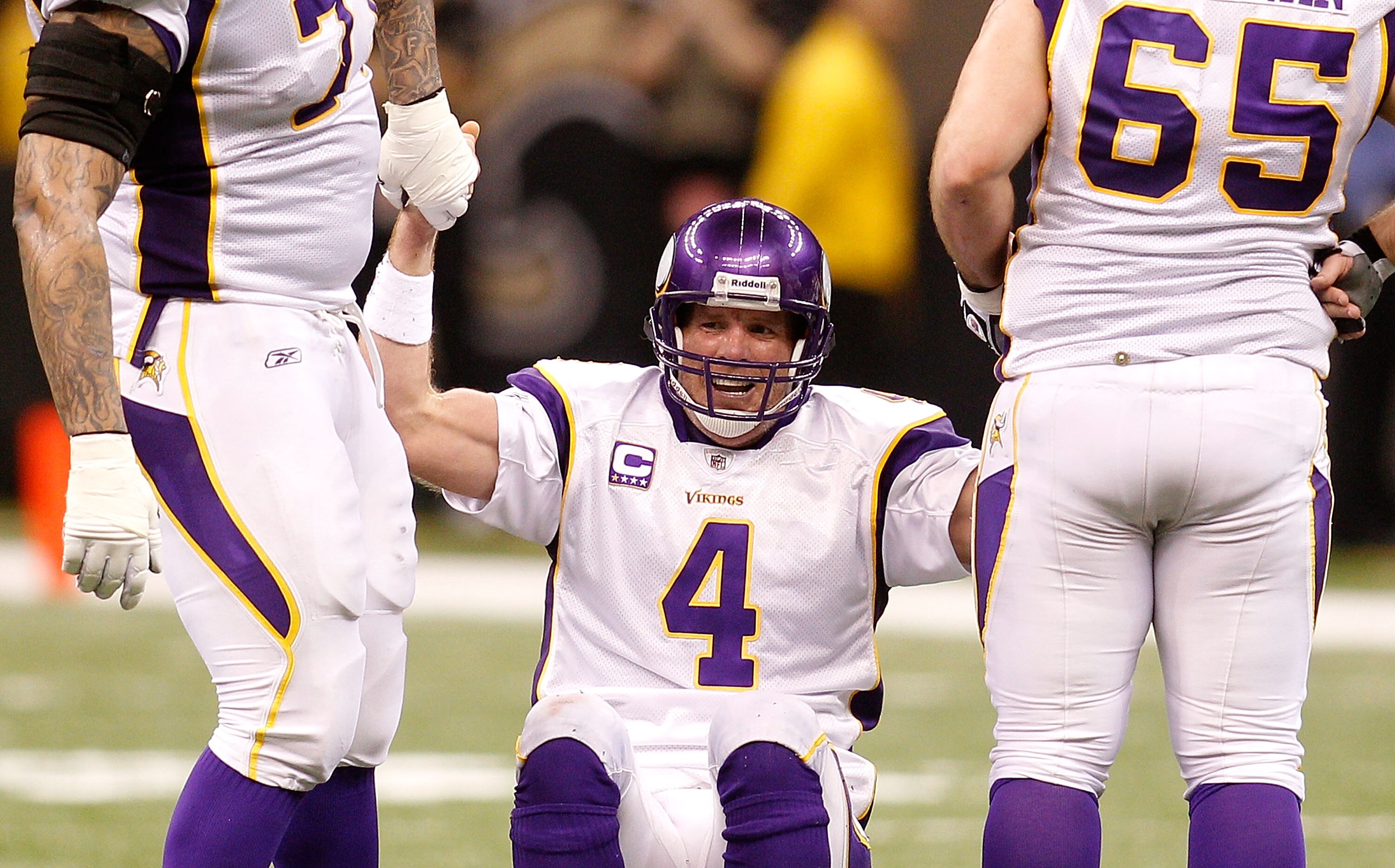 NEW ORLEANS - JANUARY 24:  Brett Favre #4 of  the Minnesota Vikings is helped up by teammates after he took a hard hit in the second half against the New Orleans Saints during the NFC Championship Game at the Louisiana Superdome on January 24, 2010 in New