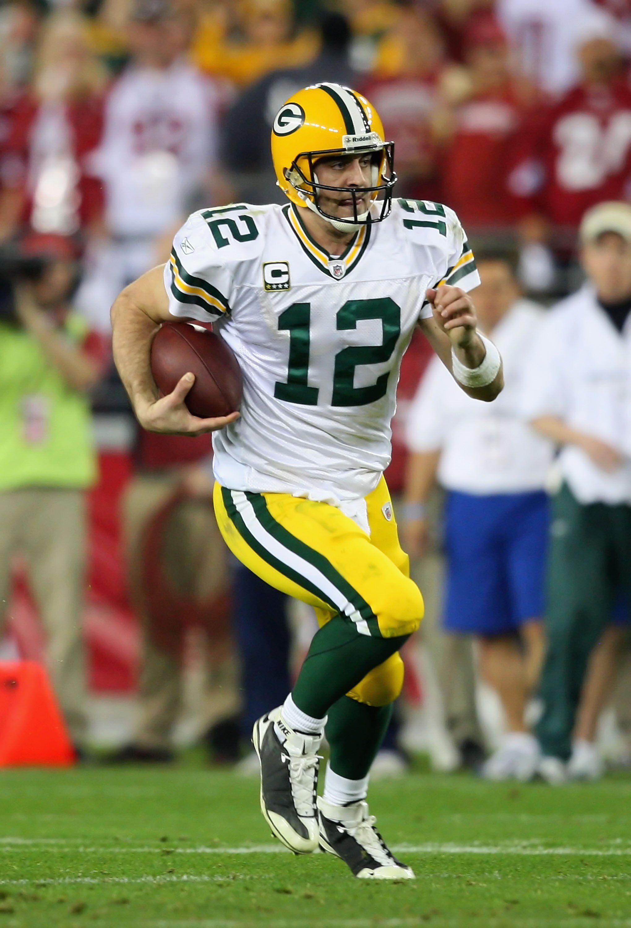 GLENDALE, AZ - JANUARY 10:  Quarterback Aaron Rodgers #12 of the Green Bay Packers scrambles with the ball during the 2010 NFC wild-card playoff game against the Arizona Cardinals at the Universtity of Phoenix Stadium on January 10, 2010 in Glendale, Ariz