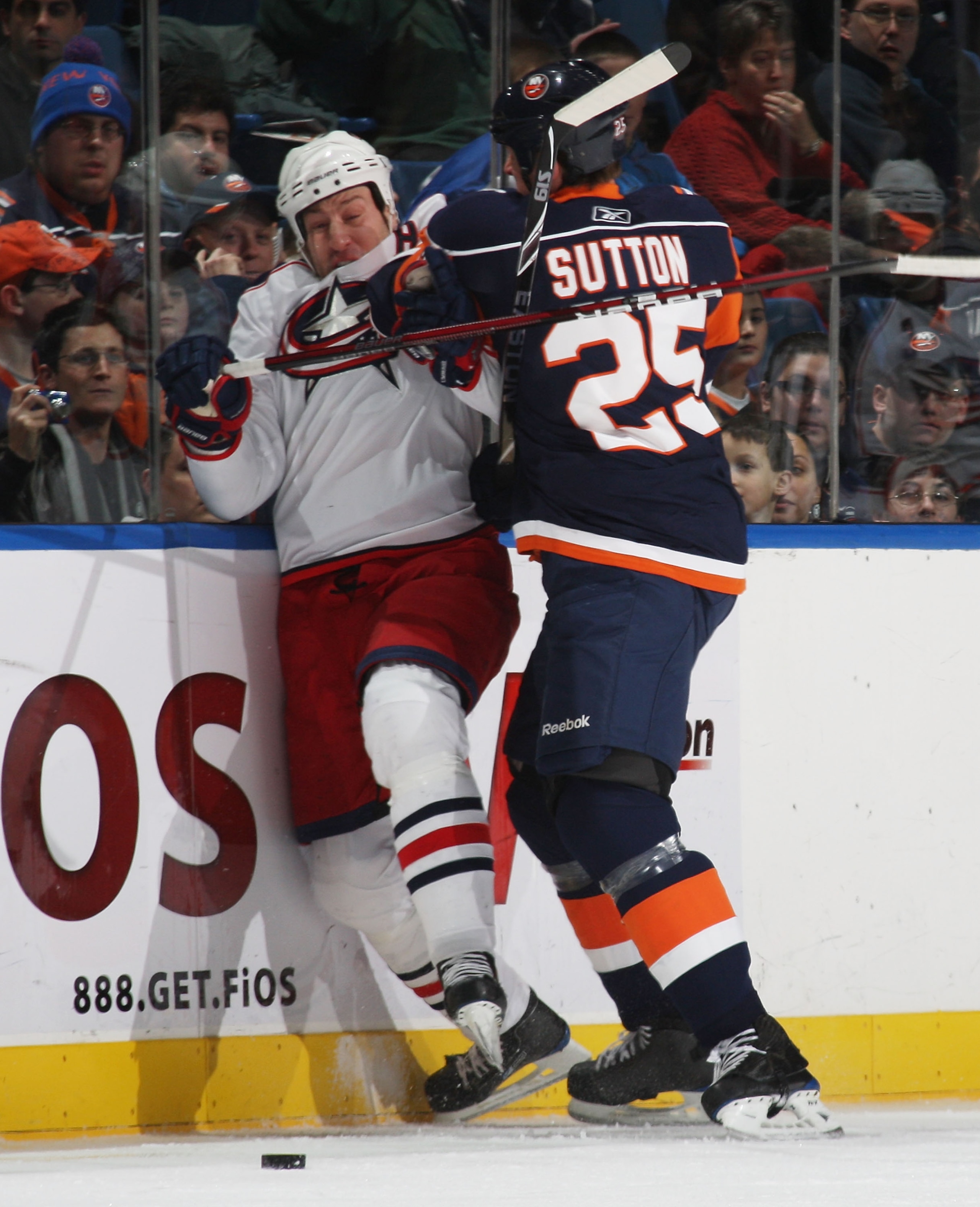 UNIONDALE, NY - DECEMBER 29: R.J. Umberger #18 of the Columbus Blue Jackets is hit by Andy Sutton #25 of the New York Islanders at the Nassau Coliseum on December 29, 2009 in Uniondale, New York. (Photo by Bruce Bennett/Getty Images)