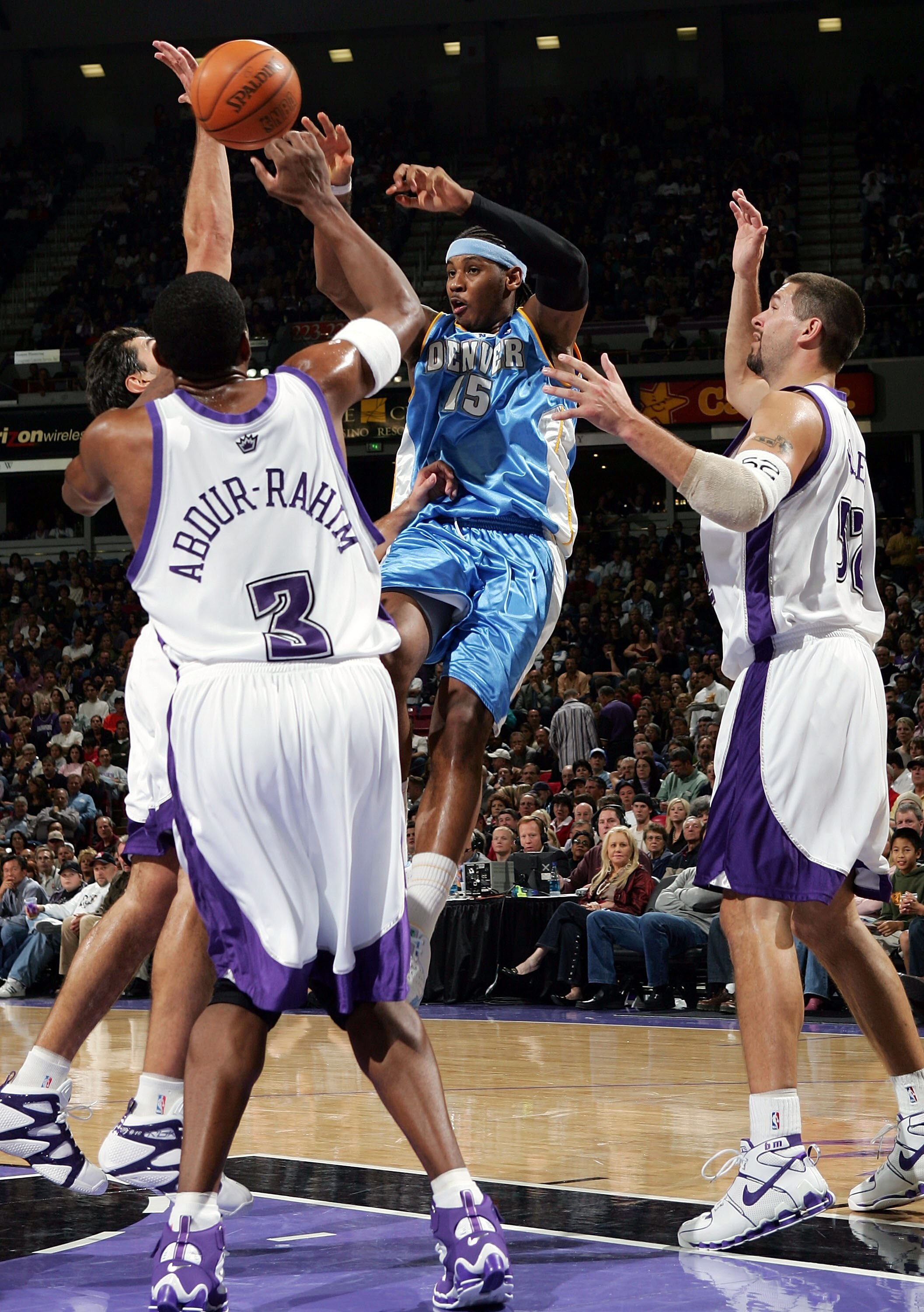 SACRAMENTO, CA - NOVEMBER 11:  Carmelo Anthony #15 of the Denver Nuggets passes over Shareef Abdur-Rahim #3 and Brad Miller #52 of the Sacramento Kings during an NBA game at Arco Arena on November 11, 2005 in Sacramento, California.  NOTE TO USER: User ex