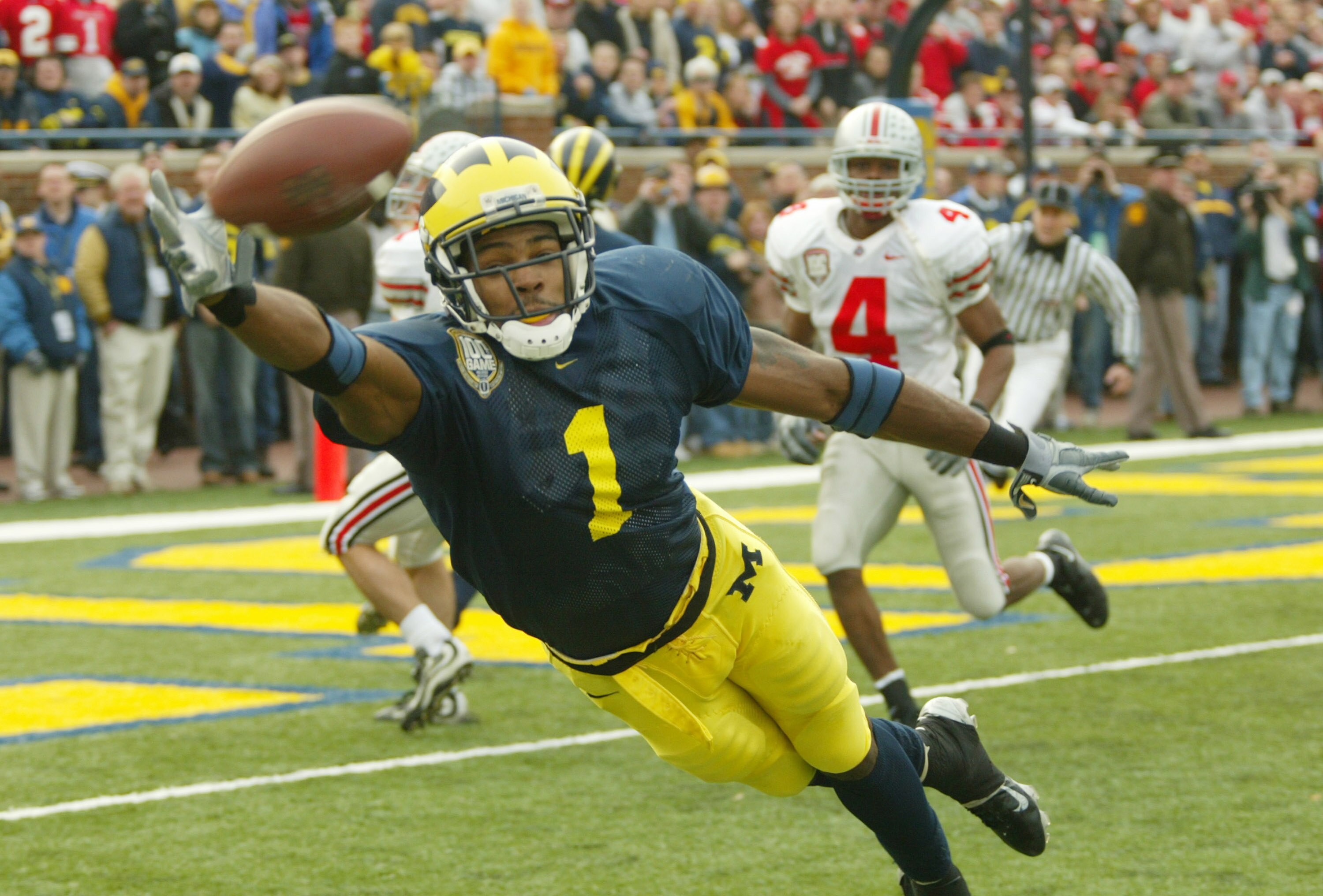 ANN ARBOR, MI - NOVEMBER 22: Braylon Edwards #1 of the Michigan Wolverines dives for a pass from John Navarre as Will Allen #4 of the Ohio State Buckeyes watches behind him during the 100th meeting of the two teams November 22, 2003 at Michigan Stadium in