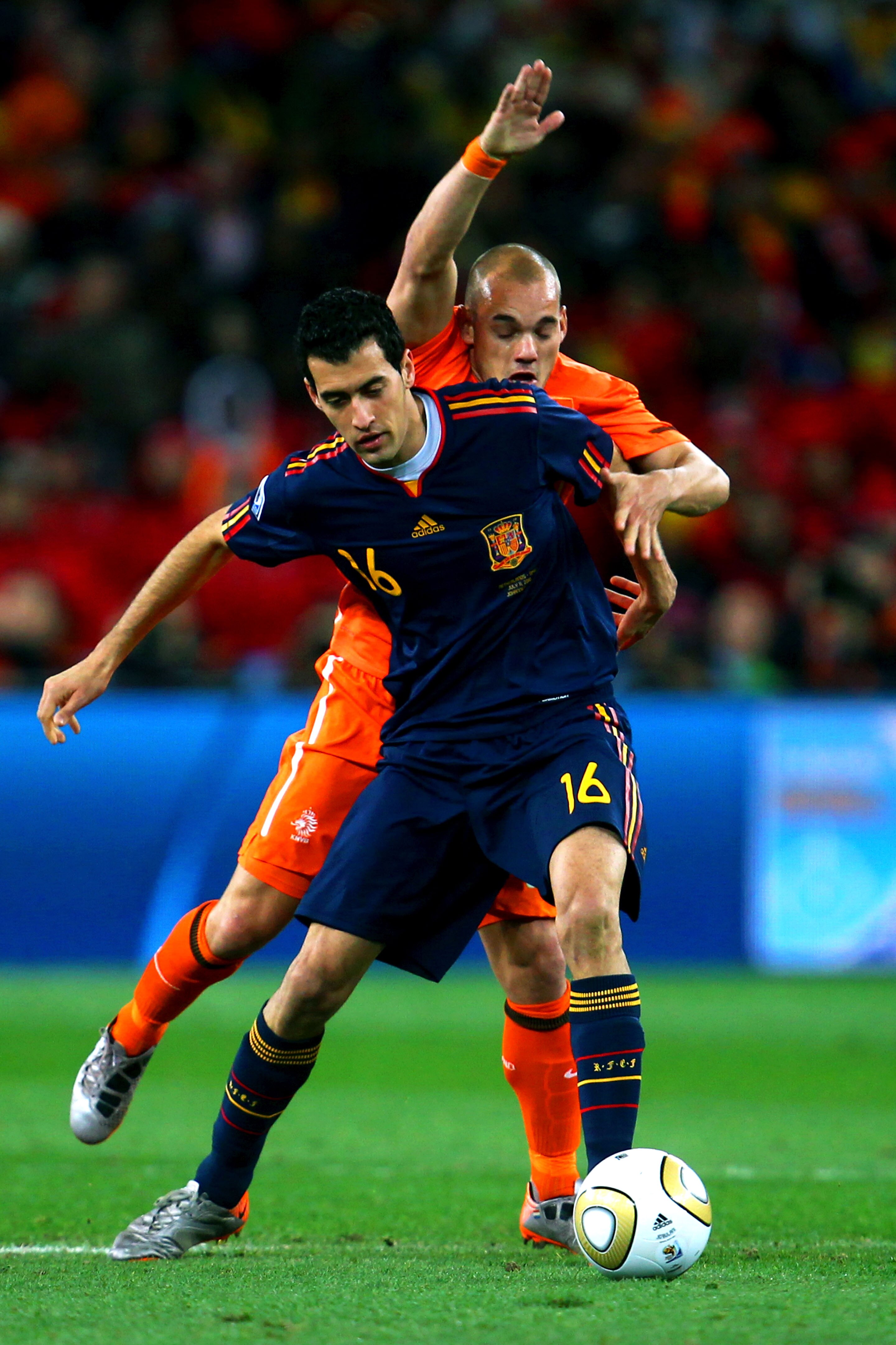 JOHANNESBURG, SOUTH AFRICA - JULY 11:  Wesley Sneijder of the Netherlands challenges Sergio Busquets of Spain during the 2010 FIFA World Cup South Africa Final match between Netherlands and Spain at Soccer City Stadium on July 11, 2010 in Johannesburg, So