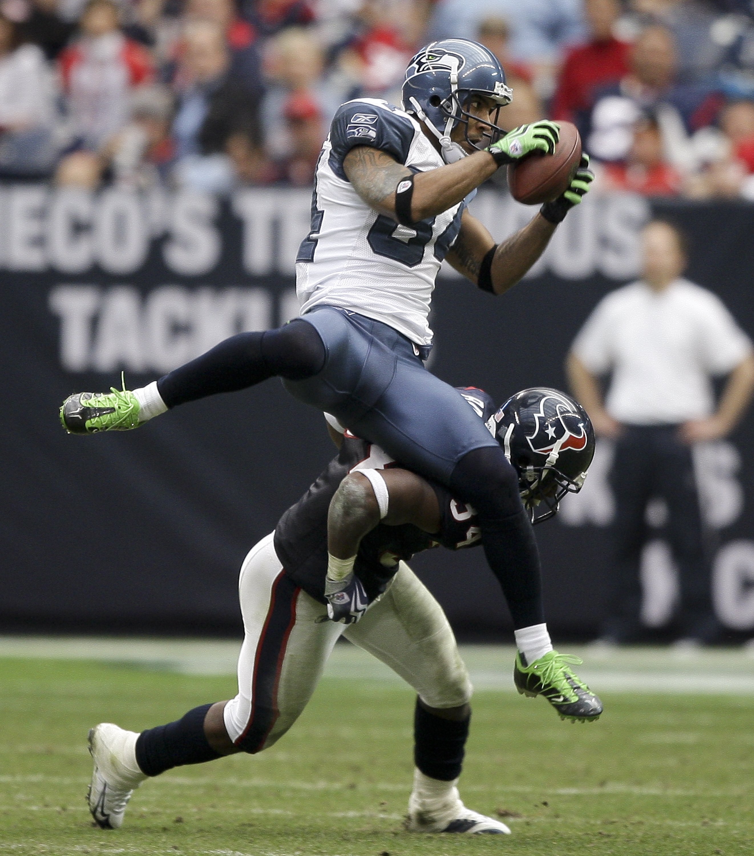 HOUSTON - DECEMBER 13:  Wide receiver T.J. Houshmandzadeh #84 of the Seattle Seahawks is upended by strong safety Dominique Barber #84 of the Seatle Seahawks as he attempts to make a catch at Reliant Stadium on December 13, 2009 in Houston, Texas.  (Photo