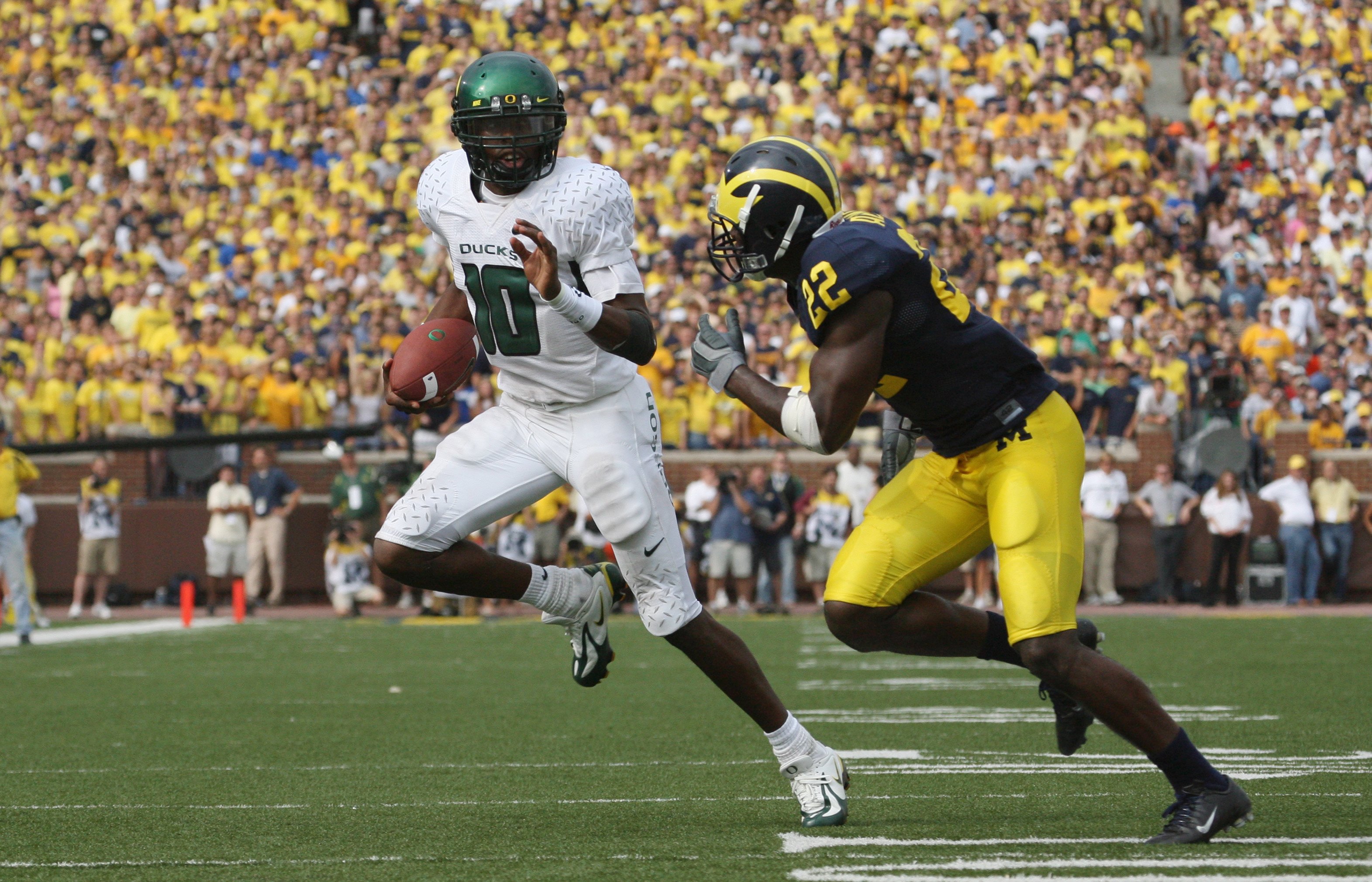 ANN ARBOR, MI - SEPTEMBER 08:  Dennis Dixon #10 of the Oregon Ducks scrambles as he is pressured by Doug Rogan #22 of the Michigan Wolverines during their game on September 8, 2007 at Michigan Stadium in Ann Arbor, Michigan.  The Ducks defeated the Wolver