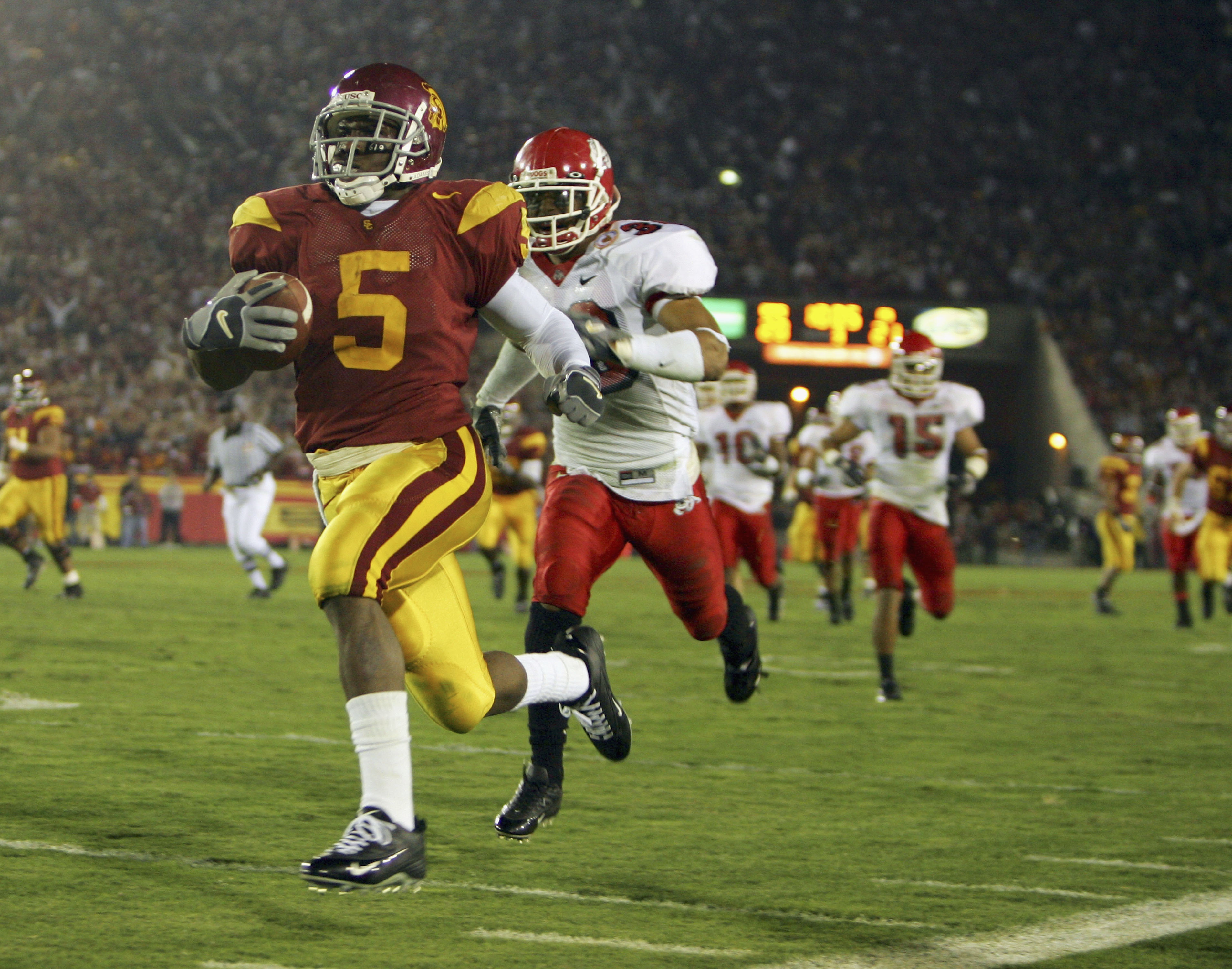 LOS ANGELES, CA - NOVEMBER 19:  Reggie Bush #5 of the USC Trojans carries the ball past Matt Davis #26 of the Fresno State Bulldogs during the game at the Los Angeles Memorial Coliseum on November 19, 2005 in Los Angeles, California. The Trojans won 50-42
