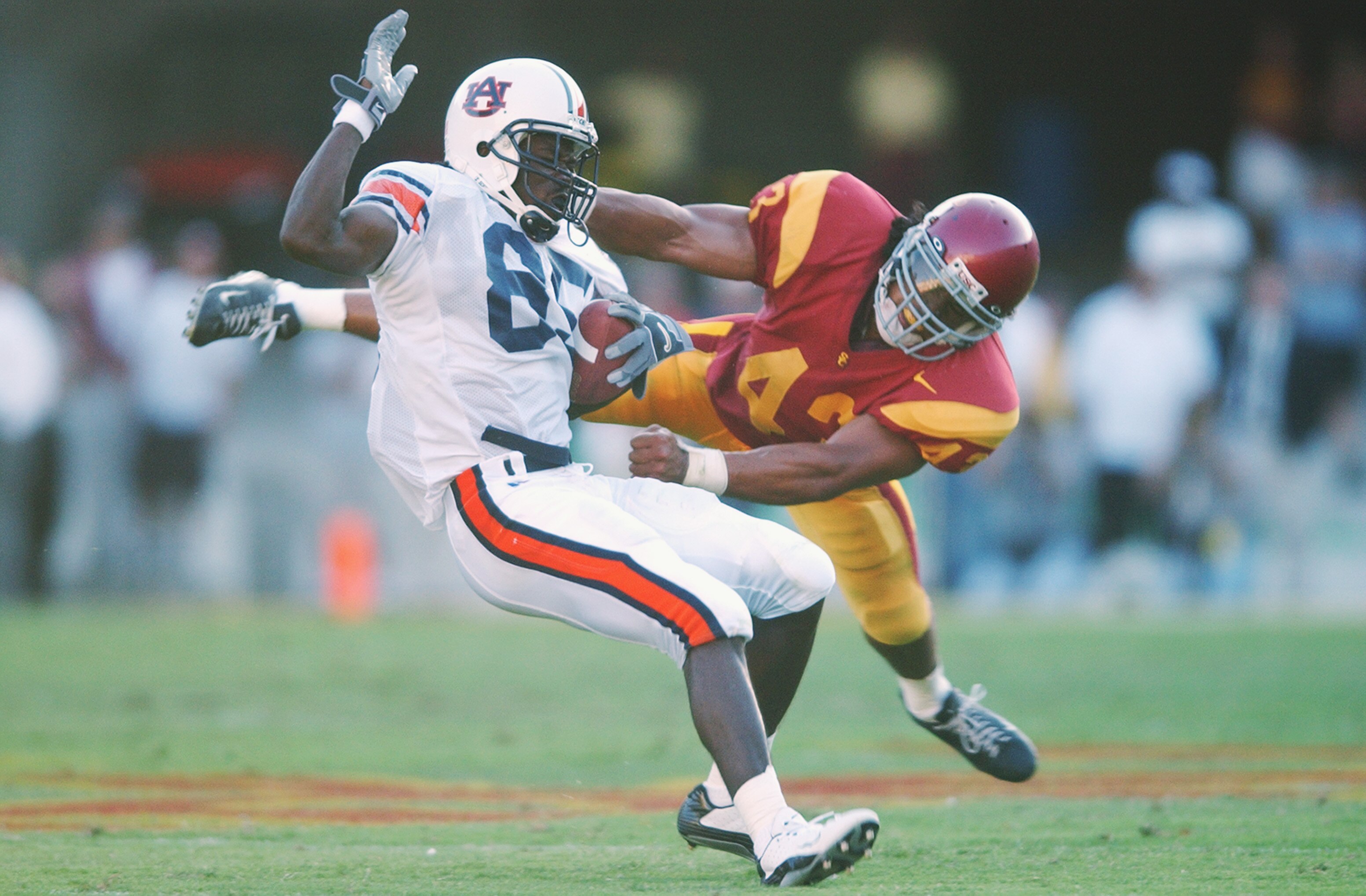 LOS ANGELES - SEPTEMBER 2:  Wide Receiver Silas Daniels #85 of the Auburn Tigers is tackled from behind by strong safety Troy Polamalu #43 of USC during the second quarter at The Los Angeles Coliseum on September 2, 2002 in Los Angeles, California.  USC d