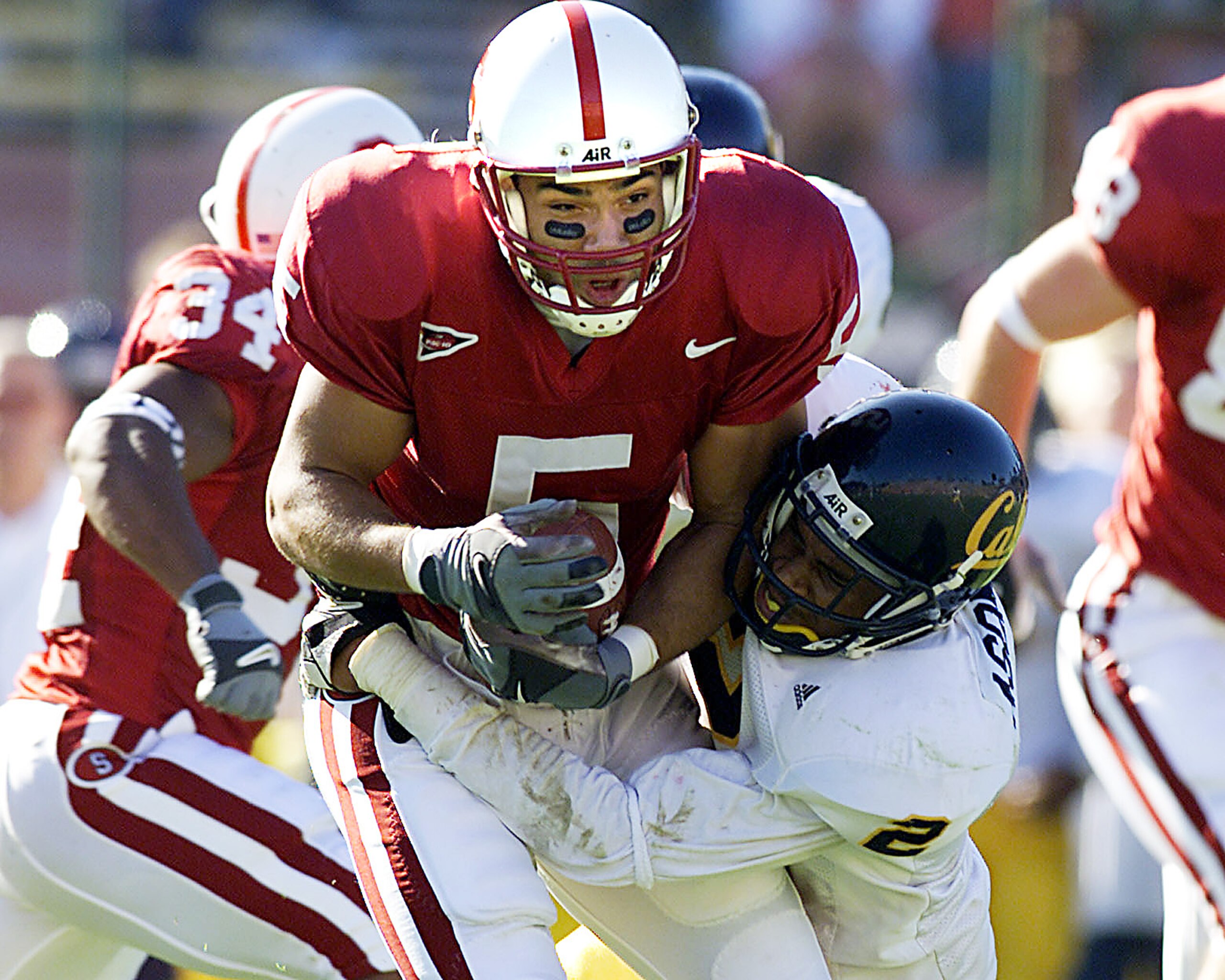 17 Nov 2001:  Teyo Johnson #5 of the Stanford Cardinal runs against the tackle of Nnamdi Asomucha #2 of the University of California, Berkeley Golden Bears during California v Stanford at Stanford Stadium in Palo Alto, California.  DIGITAL IMAGE. Mandator