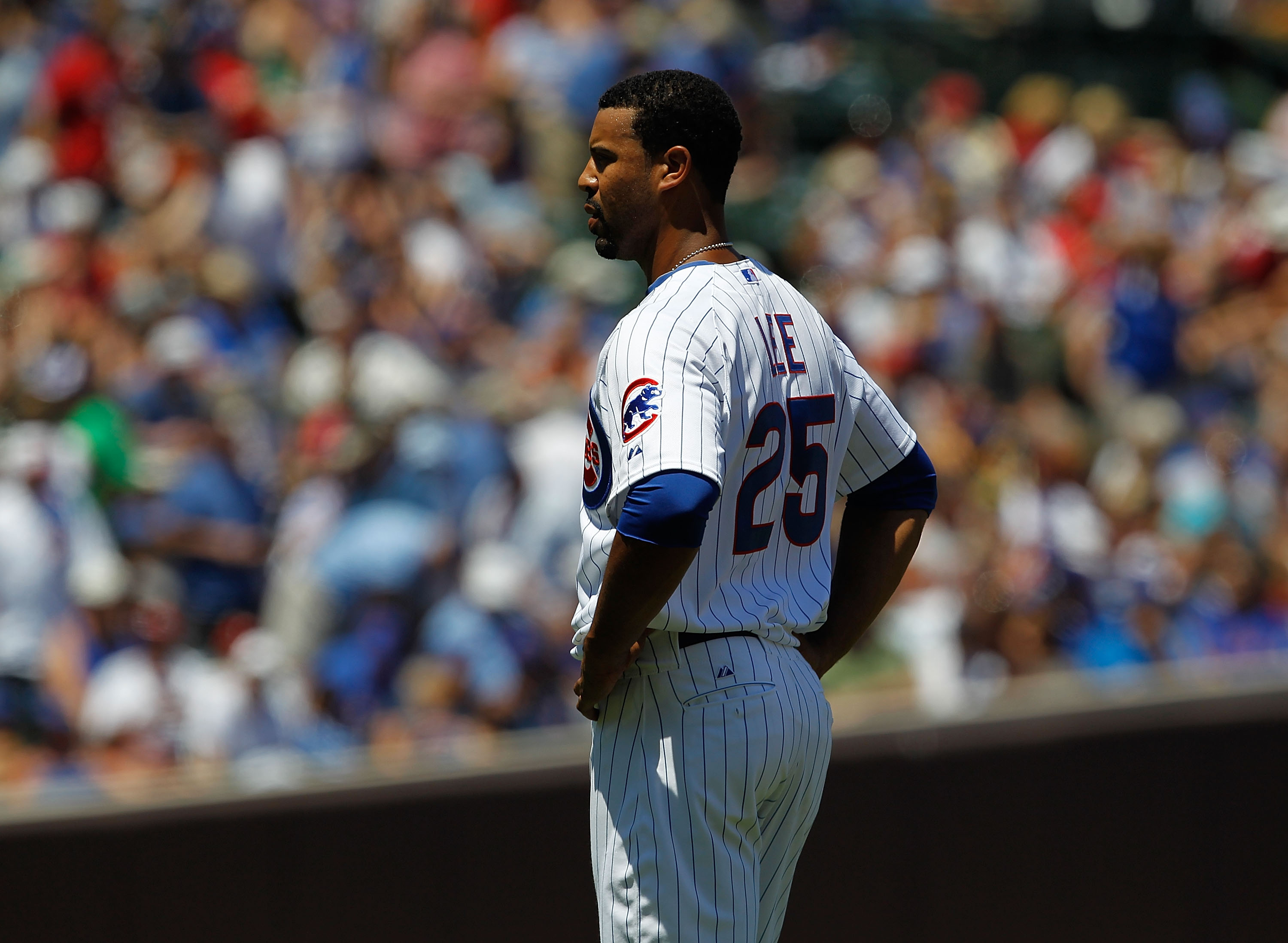 CHICAGO - JULY 03: Derrek Lee #25 of the Chicago Cubs stands and waits for a teammate to bring him his hat and glove after flying out to end an inning against the Cincinnati Reds at Wrigley Field on July 3, 2010 in Chicago, Illinois. The Cubs defeated the