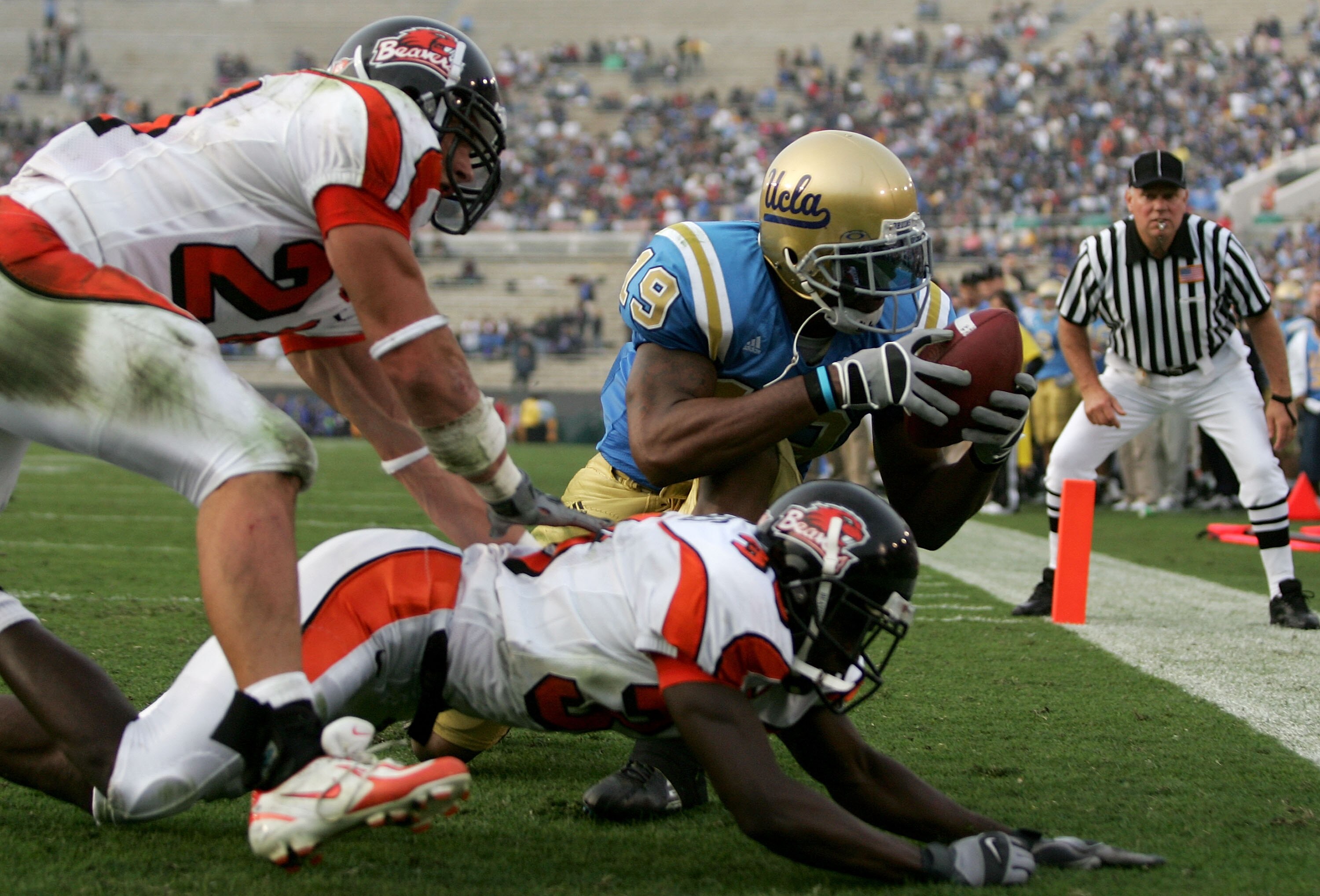 PASADENA, CA - OCTOBER 22:  Marcedes Lewis #19 of the UCLA Bruins catches a touchdown pass over Sabby Piscitelli #24 and Brandon Hughes #36 of the Oregon State Beavers during their game on October 22, 2005 at the Rose Bowl in Pasadena, California.  (Photo