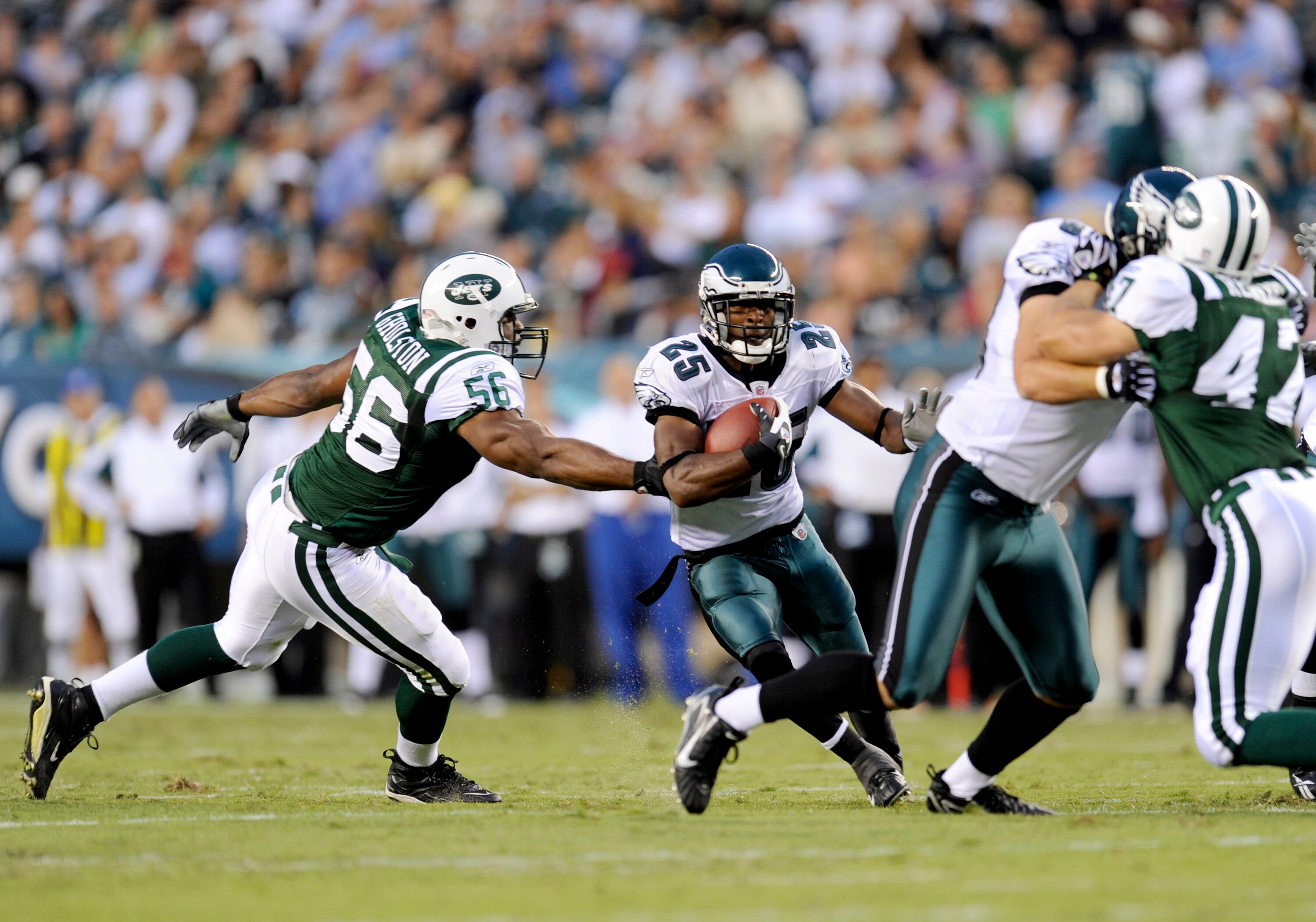 PHILADELPHIA - AUGUST 28: Lorenzo Booker #25 of the Philadelphia Eagles rushes as Vernon Gholston #56 of the New York Jets tries to make a tackle during a preseason game at Lincoln Financial Field on August 28, 2008 in Philadelphia, Pennsylvania. (Photo b