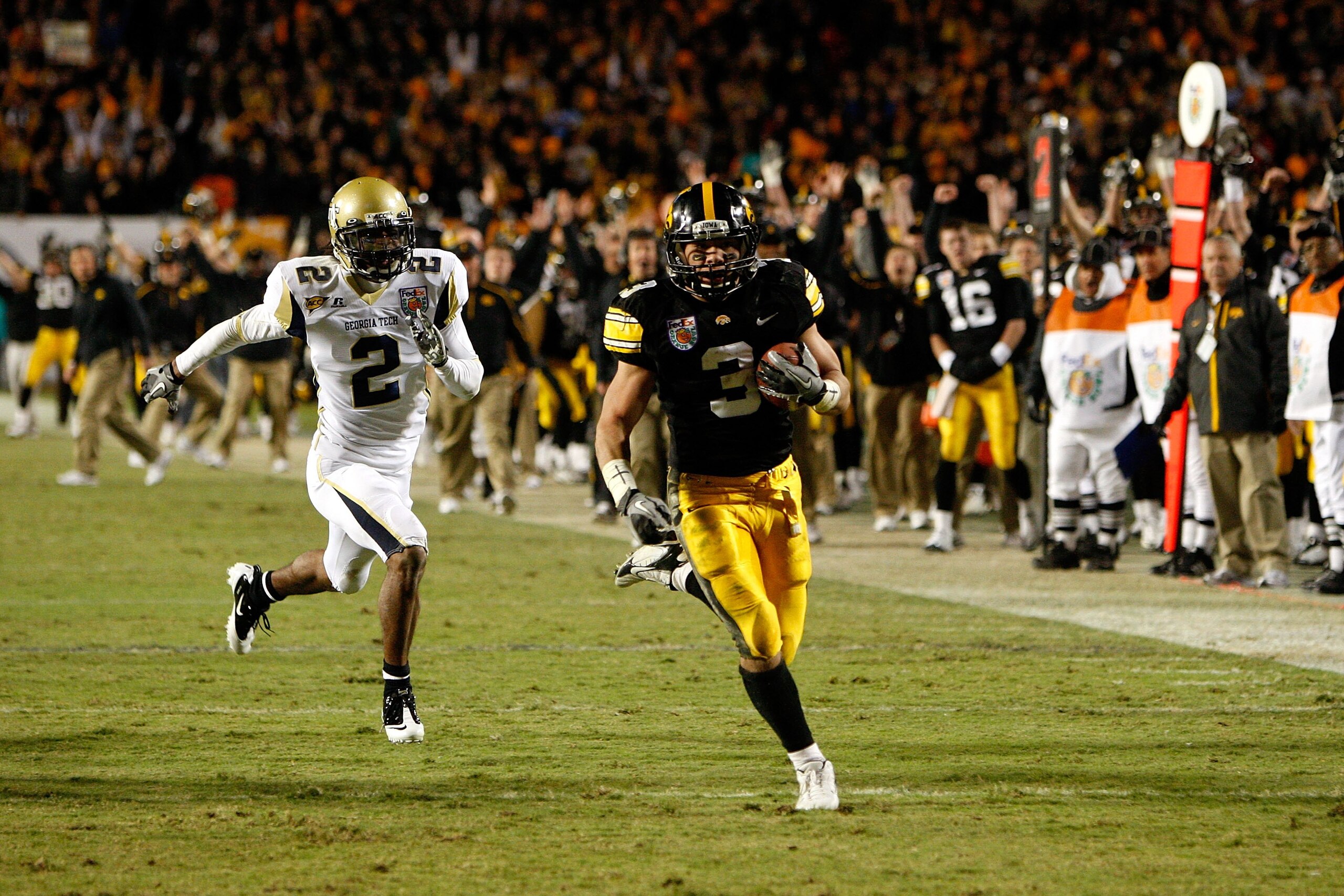 MIAMI GARDENS, FL - JANUARY 05:  Brandon Wegher #3 of the Iowa Hawkeyes scores a 32-yard rushing touchdown late in the fourth quarter against Mario Butler #2 of the Georgia Tech Yellow Jackets during the FedEx Orange Bowl at Land Shark Stadium on January