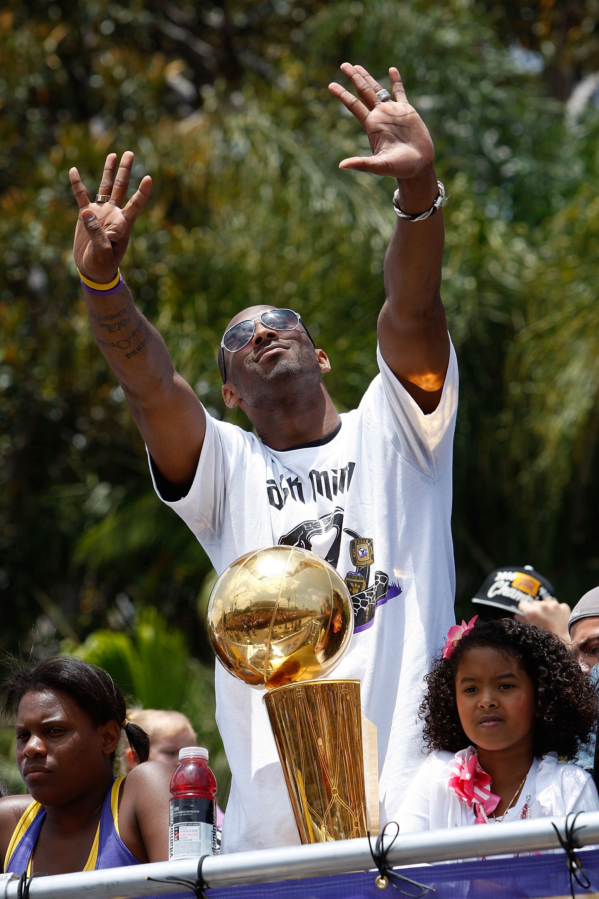 LOS ANGELES, CA - JUNE 21:  Los Angeles Lakers guard Kobe Bryant (C)  acknowledges his fans with his four-year-old daughter Gianna Maria-Onore (R) at his side and the championship trophy while riding in the victory parade for the the NBA basketball champi